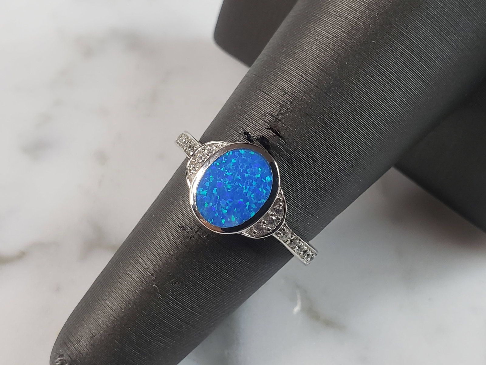 Womens Estate Sterling Silver Modernist Blue Opal Ring: A WOMENS ESTATE STERLING SILVER MODERNIST BLUE OPAL COLORED RING. THE RING IS A SIZE 6.0 AND WEIGHS 2.7g. WIDTH OF RING MEASURES 3/8". NOT SURE IF STONE IS NATURAL OR MAN MADE. THE RING MAKES A BEAUTI