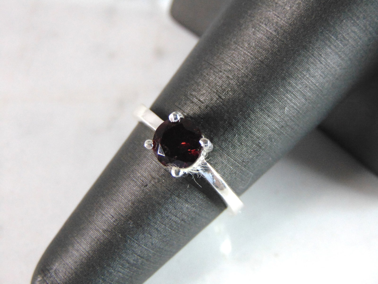 Womens Sterling Silver Ring w/ Garnet Colored Stone: FOR SALE IS THIS WONDERFUL WOMENS STERLING SILVER RING WITH A GARNET COLORED STONE. NOT SURE IF THE STONE IS NATURAL OR MAN MADE. THE RING WEIGHS 2.6g. THE SIZE OF THE RING IS A 5.5. ANY QUESTIONS PLE