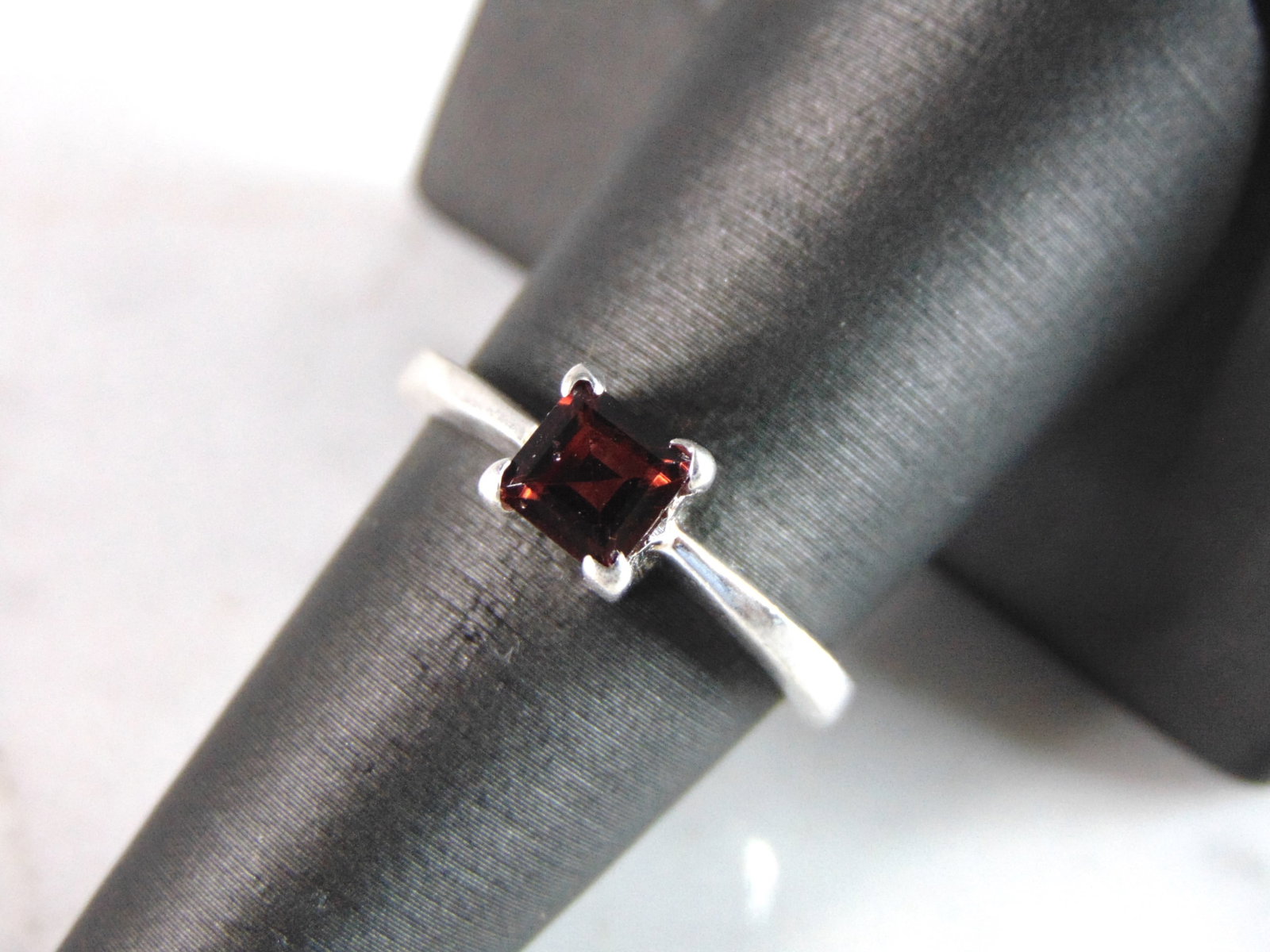 Womens Sterling Silver Ring w/ Garnet Colored Stone: FOR SALE IS THIS WONDERFUL WOMENS STERLING SILVER RING WITH A GARNET COLORED STONE. NOT SURE IF THE STONE IS NATURAL OR MAN MADE. THE RING WEIGHS 3.9g. THE SIZE OF THE RING IS A 8.0. ANY QUESTIONS PLE
