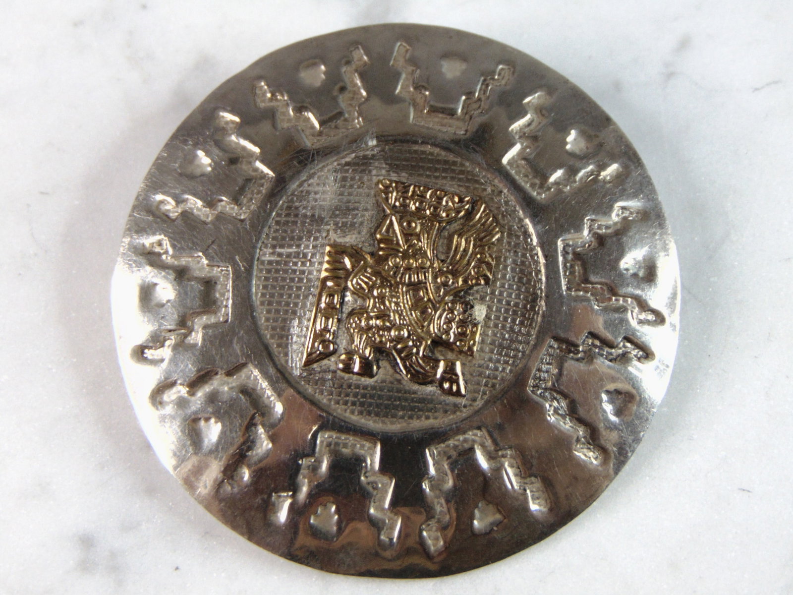 Womens Vintage Estate Sterling Silver & 18k Gold Mayan Inca Brooch: A WOMENS VINTAGE ESTATE STERLING SILVER & 18k GOLD INCA BROOCH. THE TOTAL WEIGHT OF THE BROOCH IS 12.0g. THE BROOCH MEASURES 3 1/4" IN DIAMETER. MAKES A GREAT GIFT FOR THAT SPECIAL SOMEONE. ANY QUESTI