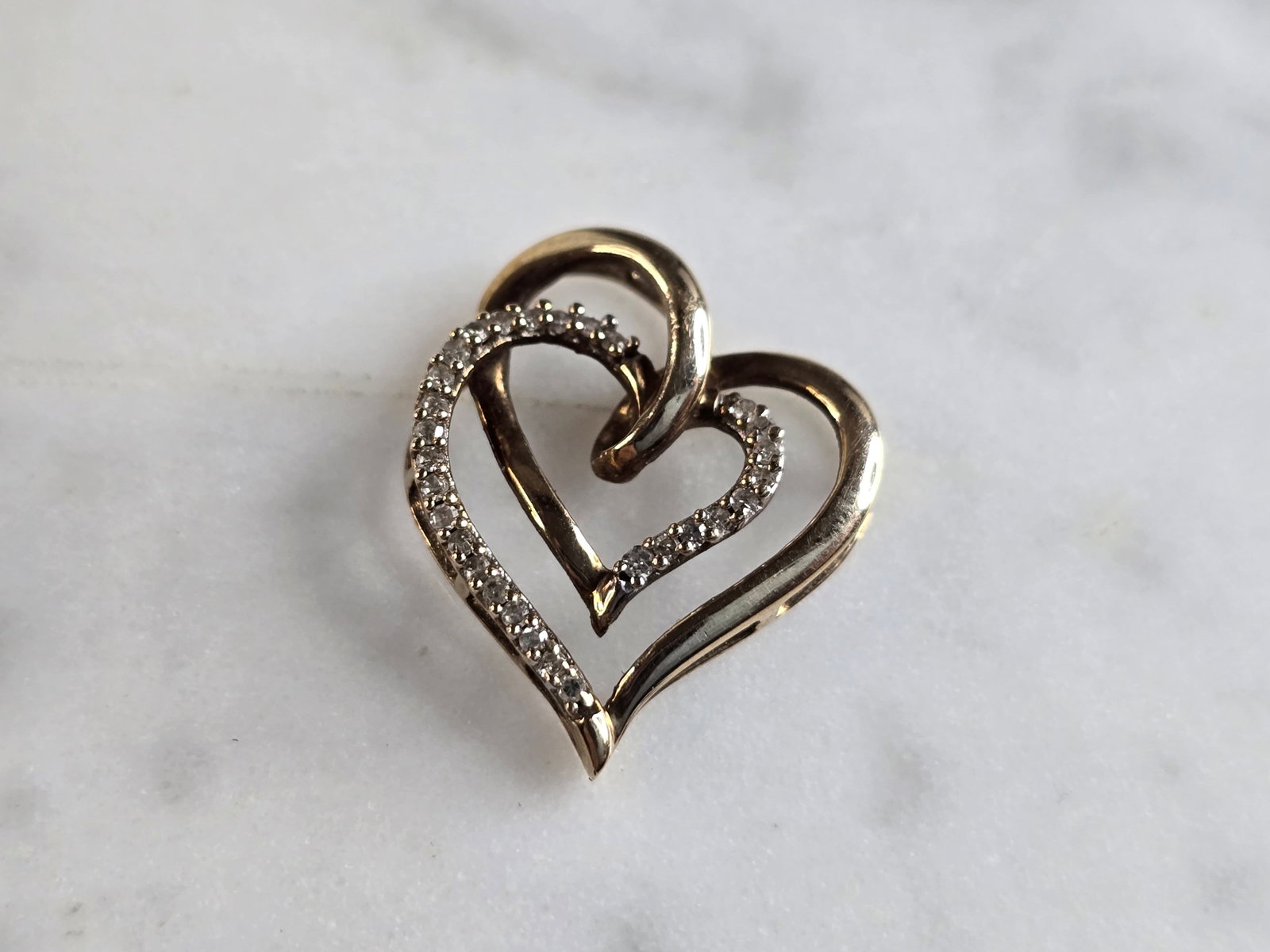 Womens Vintage Estate 10K Gold Diamond Heart Pendant: A WOMENS VINTAGE ESTATE 10K GOLD DIAMOND HEART PENDANT. PENDANT HAS A TOTAL OF 28 DIAMONDS. PENDANT WEIGHS 1.5g, AND MEASURES 3/4" BY 5/8". WOULD MAKE A LOVELY GIFT FOR THAT SOMEONE SPECIAL. ANY QUEST