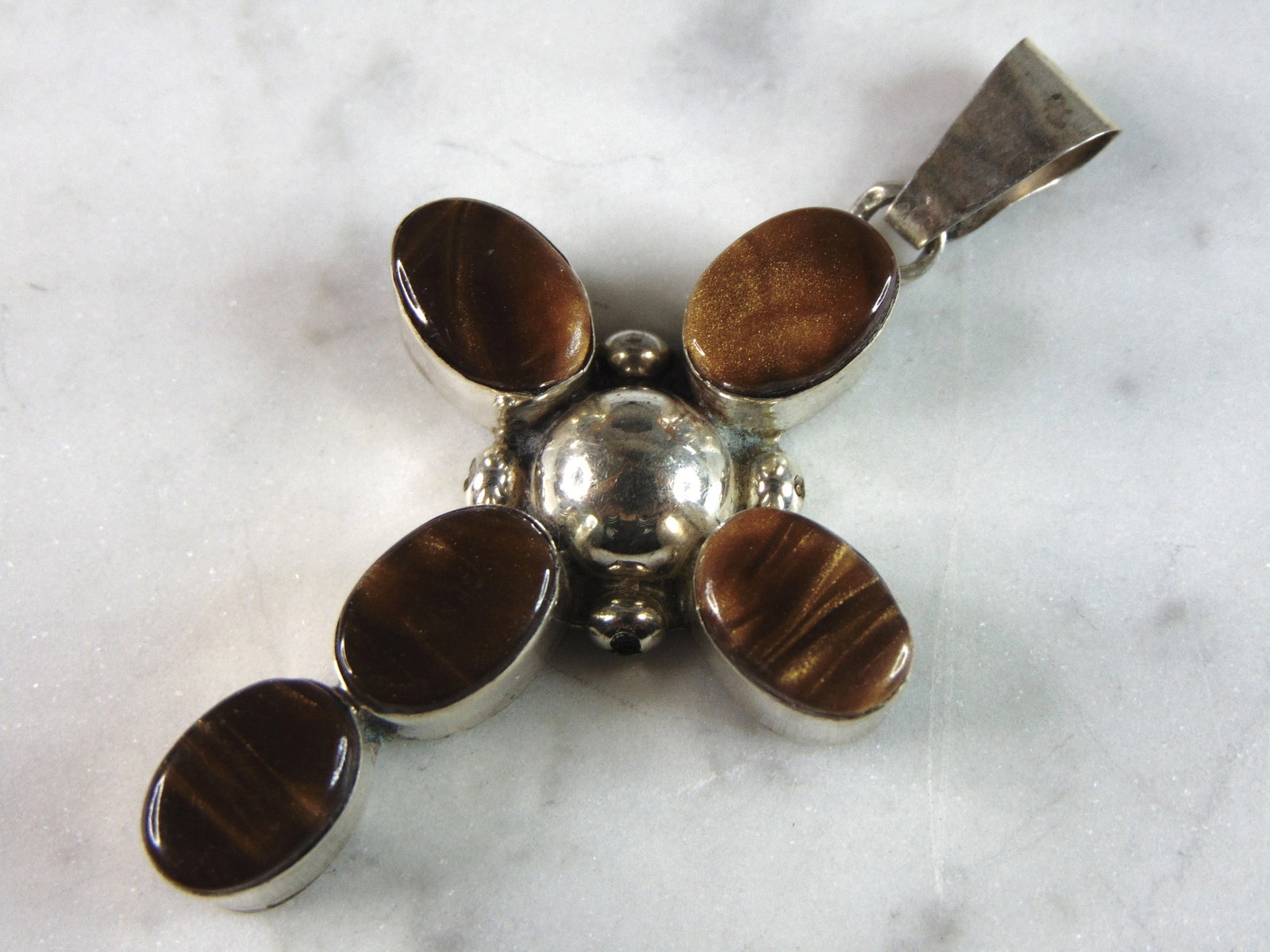 Womens Vintage Estate Sterling Silver Tiger's Eye Cross Pendant: A WOMENS VINTAGE ESTATE STERLING SILVER TIGER'S EYE CROSS PENDANT. NOT SURE IF STONES ARE NATURAL OR MAN MADE. THE PENDANT WEIGHS 12.0g AND MEASURES 2 1/2" LONG BY 1 3/8" WIDE. MAKES A GREAT GIFT FOR 