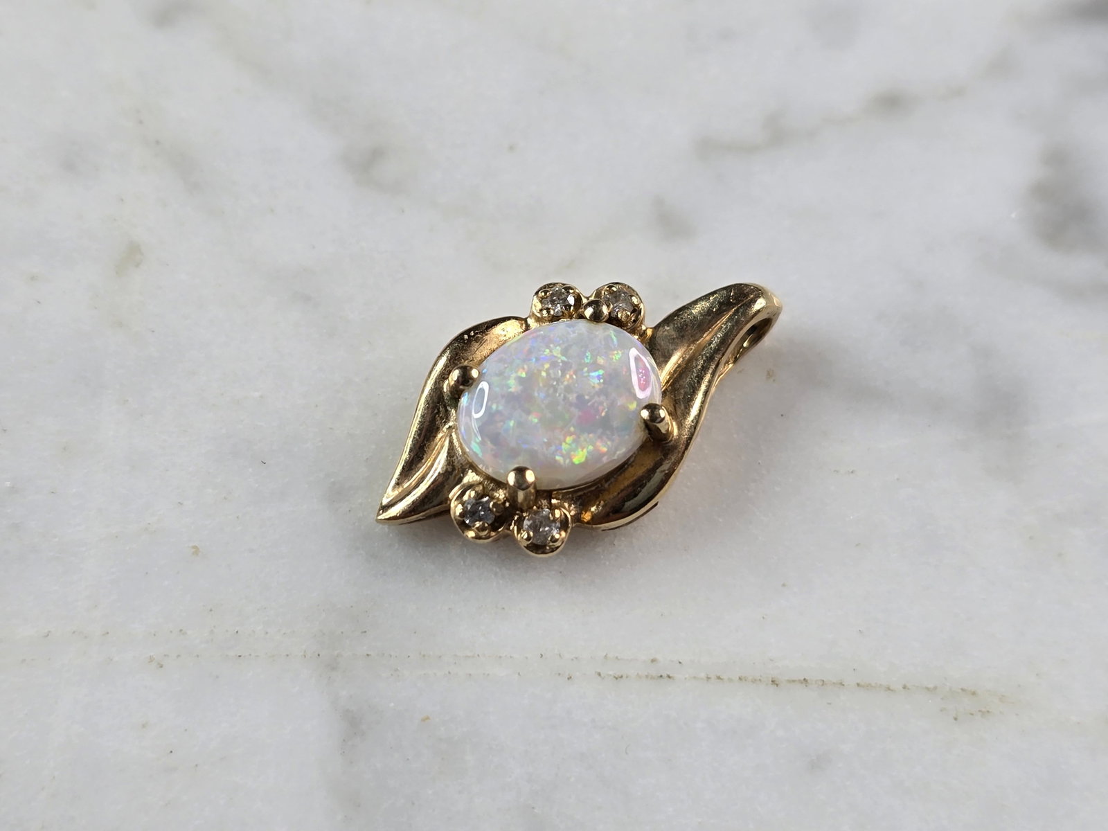 Womens Vintage Estate 14K Gold Opal Diamond Pendant: A WOMENS VINTAGE ESTATE 14K YELLOW GOLD OPAL PENDANT WITH DIAMOND ACCENTS. THE TOTAL WEIGHT IS 2.3g. THE PENDANT MEASURES 3/4" LONG BY 1/2" WIDE. THERE ARE ABOUT .04cts OF DIAMONDS. THE OPAL IS ABOUT 
