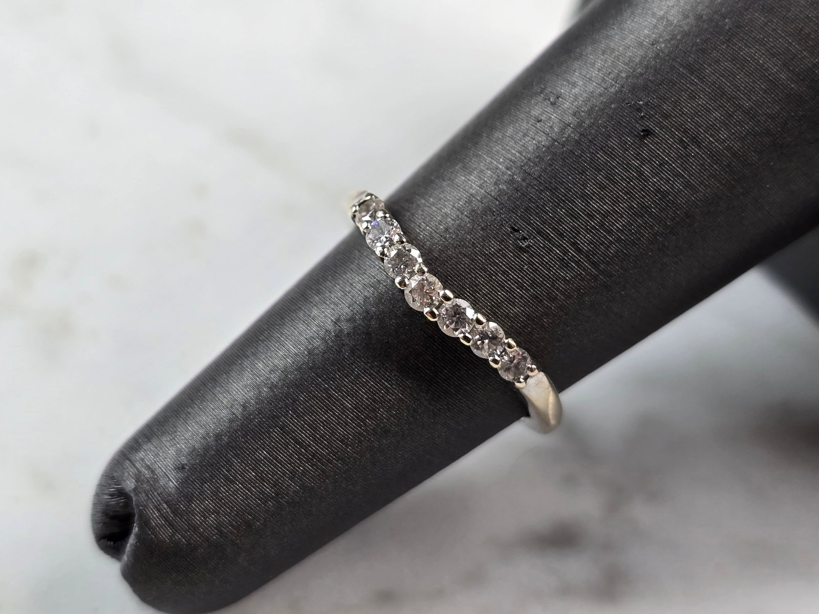 Womens Vintage Estate 14K White Gold Diamond Ring: A WOMENS VINTAGE ESTATE 14K WHITE GOLD DIAMOND RING . THE RING IS A SIZE 5.0, AND WEIGHS 1.7g. THE WIDTH OF THE RING IS 1/8". THERE ARE ABOUT 7 SMALL DIAMONDS IN THIS RING. RING IS MARKED 14K. THIS IS