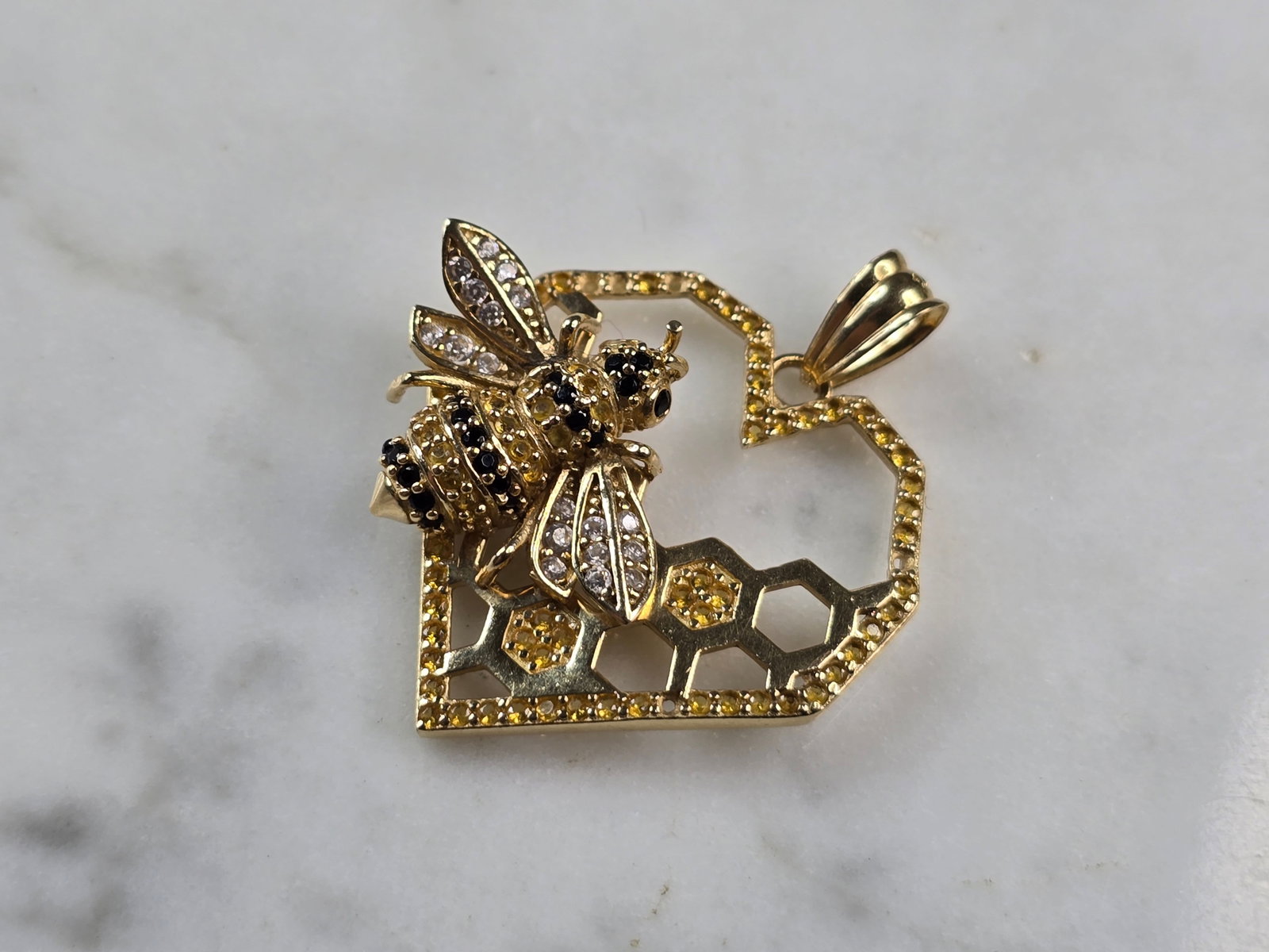 Womens Vintage Estate 14K Yellow Gold CZ Honeycomb Bee Pendant: A WOMENS VINTAGE ESTATE 14K YELLOW GOLD CZ HONEYCOMB BEE PENDANT. THE PENDANT MEASURES 1 1/4" BY 1 1/8", AND WEIGHS 4.0g. THERE ARE 5 STONES MISSING ALONG THE BORDER. BUYING AS IS. MAKES A GREAT GIFT 