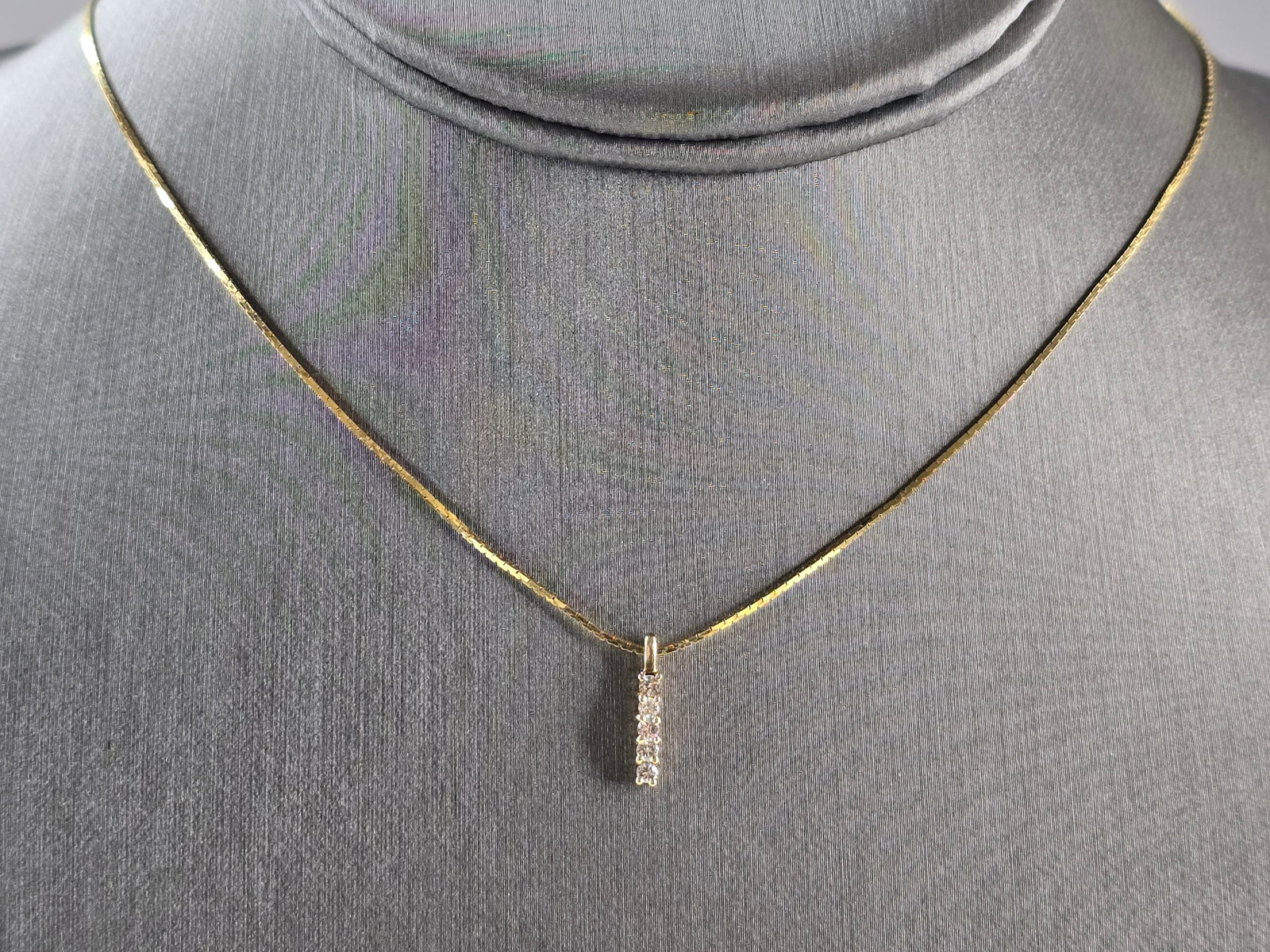 Womens Vintage Estate 14K Yellow Gold Diamond Pendant Necklace: A WOMENS VINTAGE ESTATE 14K YELLOW GOLD DIAMOND PENDANT WITH NECKLACE. THE TOTAL WEIGHT IS 3.2g. THE PENDANT MEASURES 1/2" LONG BY 1/8" WIDE. PENDANT HAS 5 SMALL DIAMONDS. THE NECKLACE MEASURES 18" LO