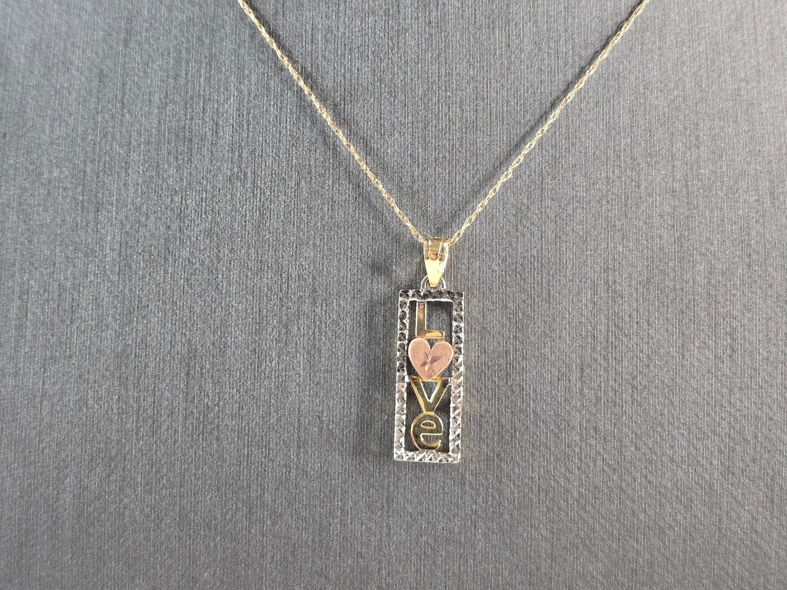 Womens Vintage Estate 10K Mixed Gold Love Pendant Necklace: A WOMENS VINTAGE ESTATE 10K MIXED GOLD "LOVE" PENDANT WITH NECKLACE. PENDANT WITH NECKLACE WEIGHS 1.7g. PENDANT MEASURES 1" BY 1/4". THE NECKLACE MEASURES 18 1/4". WOULD MAKE A LOVELY GIFT FOR THAT SO