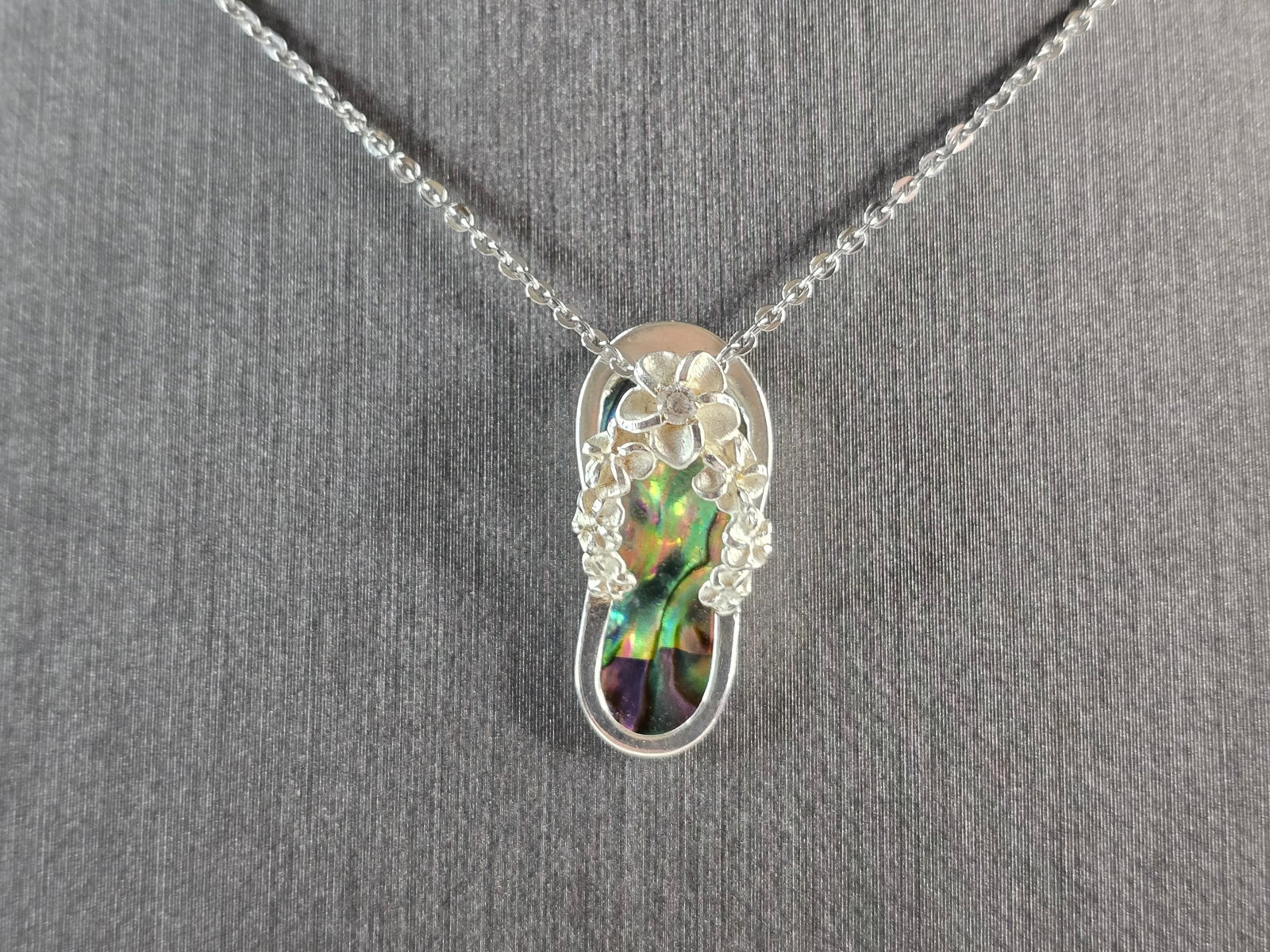 Womens Vintage Estate Sterling Silver Flip Flop Pendant Necklace: A WOMENS VINTAGE ESTATE STERLING SILVER HAWAIIAN ABALONE FLIP FLOP PENDANT WITH NECKLACE. THE PENDANT WITH NECKLACE WEIGHS 3.3g. PENDANT MEASURES 7/8" LONG BY 3/8" WIDE. NECKLACE MEASURES 18". NOT SUR