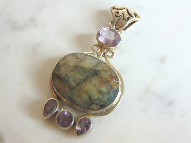Womens Vintage Sterling Silver Multi Stone Pendant: A WOMENS VINTAGE ESTATE STERLING SILVER MULTI STONE PENDANT. NOT SURE IF STONES ARE REAL OR MAN MADE. PENDANT WEIGHS 10.6g AND PENDANT MEASURES 1 7/8" LONG BY 1" WIDE. MAKES A GREAT GIFT FOR THAT SOME