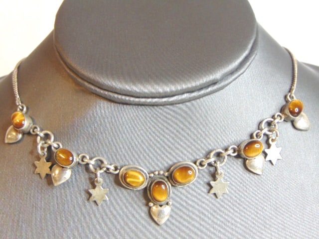 Womens Vintage Sterling Silver Tigers Eye Necklace: A WOMENS VINTAGE ESTATE STERLING SILVER TIGER EYE NECKLACE. NOT SURE IF STONE IS REAL OR MAN MADE. NECKLACE WEIGHS 18.1g AND MEASURES 17 1/2" LONG BY 7/8" WIDE. MAKES A GREAT GIFT FOR THAT SOMEONE SPE