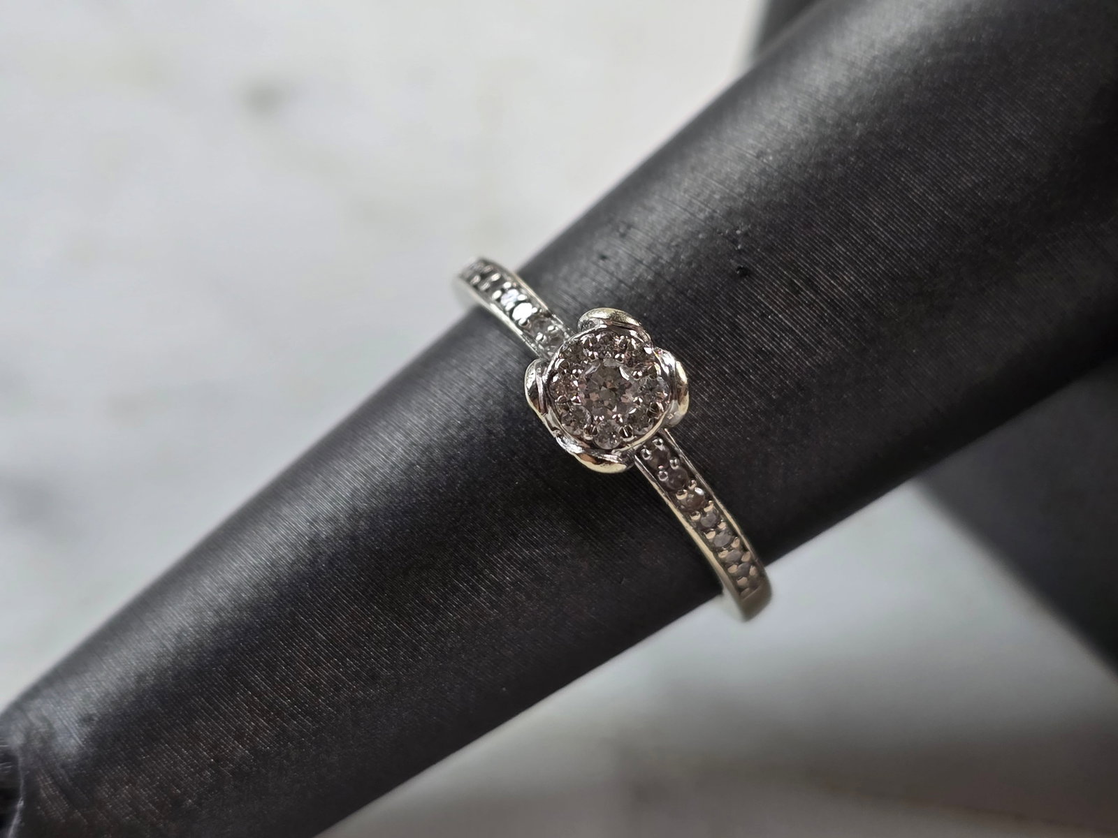 Womens Vintage Estate 10K White Gold Diamond Ring: A WOMENS VINTAGE ESTATE 10K WHITE GOLD DIAMOND RING. THE RING IS A SIZE 7.0 AND WEIGHS 2.1g. THE CENTER DIAMOND IS ABOUT .05cts, WITH 22 TINY ACCENT DIAMONDS. RING MEASURES ABOUT 1/4" WIDE , AND IS MA