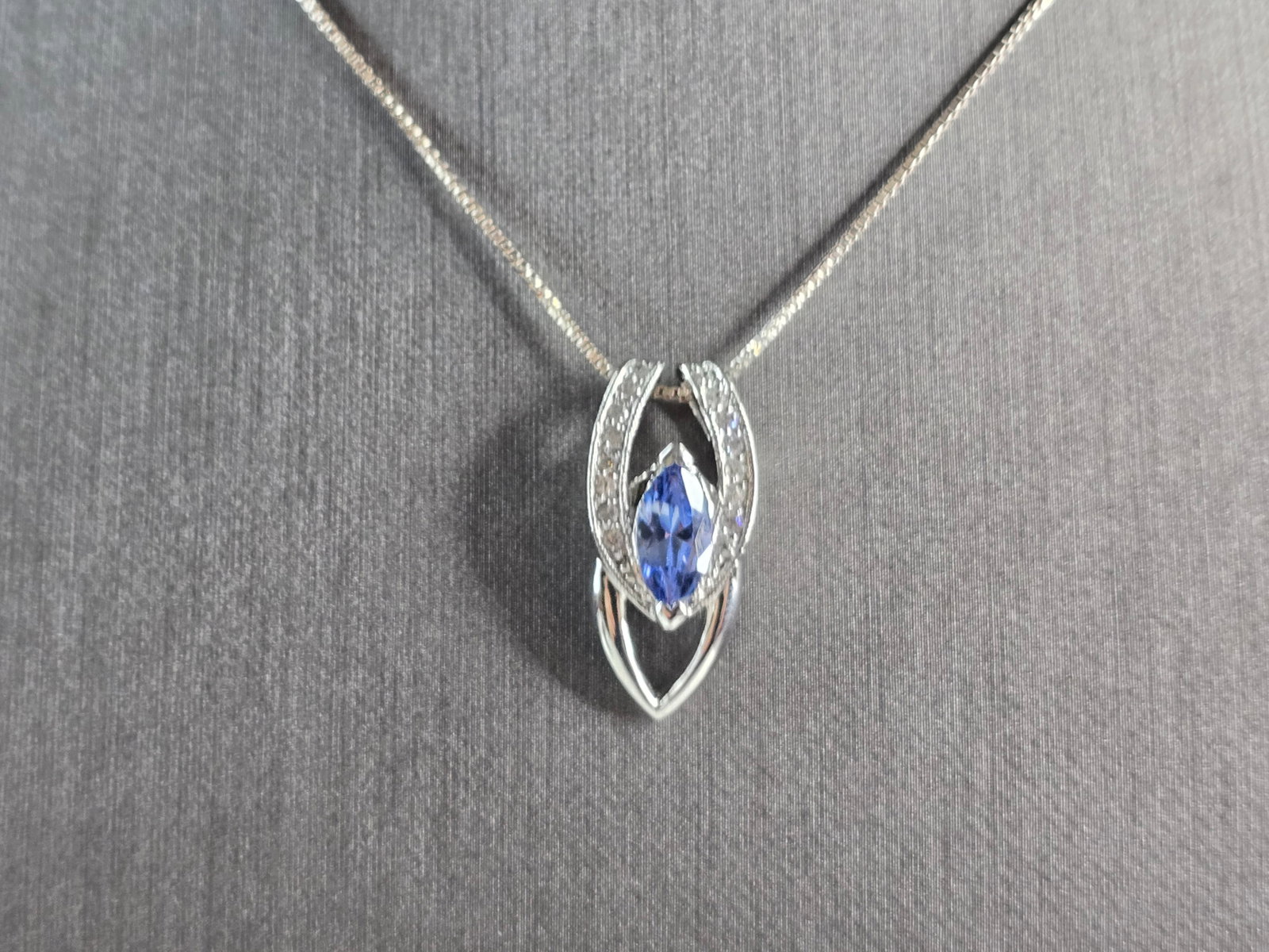 Womens Vintage Sterling Silver Modernist Tanzanite Pendant Necklace: A WOMENS VINTAGE ESTATE STERLING SILVER MODERNIST PENDANT AND NECKLACE WITH A TANZANITE COLORED STONE. THE TOTAL WEIGHT IS 5.5g. PENDANT MEASURES 7/8" LONG BY 1/2" WIDE, AND NECKLACE IS 18" LONG. NOT 