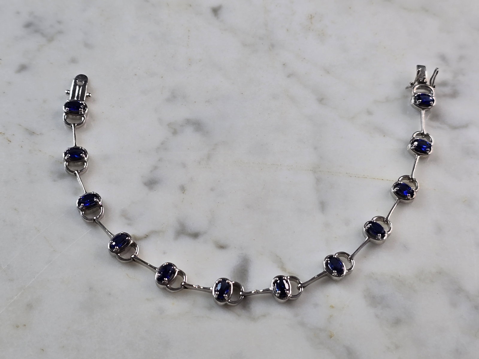 Womens Vintage Estate Sterling Silver Modernist Sapphire Bracelet: A WOMENS VINTAGE ESTATE STERLING SILVER MODERNIST TENNIS BRACELET WITH BLUE SAPPHIRE COLORED STONES. THE BRACELET MEASURES 7 1/4" LONG BY 1/4" WIDE, AND WEIGHS 10.4g. NOT SURE IF THE STONES ARE NATURA