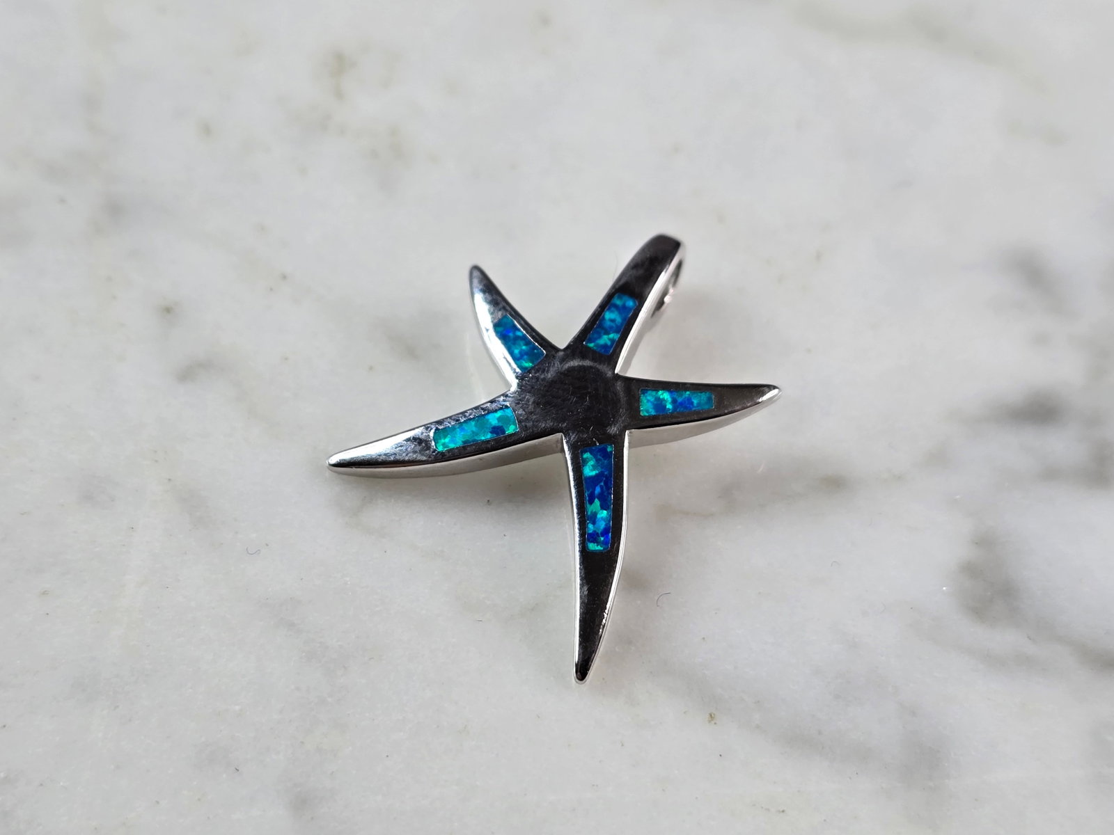 Womens Sterling Silver Starfish Blue Opal Pendant: A WOMENS STERLING SILVER STARFISH BLUE OPAL PENDANT. THE PENDANT WEIGHS 2.7g, AND MEASURES 1" LONG BY 7/8" WIDE. NOT SURE IF OPAL IS NATURAL OR MAN MADE. MAKES A GREAT GIFT FOR THAT SOMEONE SPECIAL. A