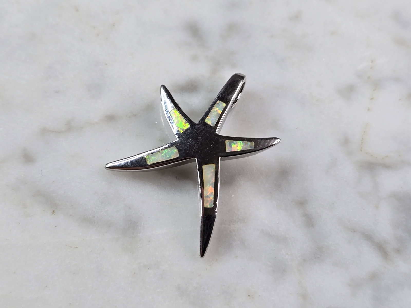 Womens Sterling Silver Starfish Opal Pendant: A WOMENS STERLING SILVER STARFISH OPAL PENDANT. THE PENDANT WEIGHS 2.7g, AND MEASURES 1" LONG BY 7/8" WIDE. NOT SURE IF OPAL IS NATURAL OR MAN MADE. MAKES A GREAT GIFT FOR THAT SOMEONE SPECIAL. ANY QU