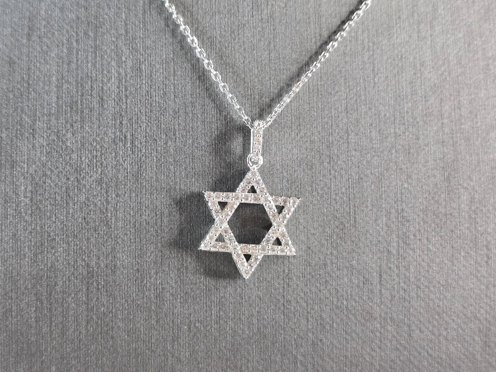 Sterling Silver Jewish Judaica Star of David CZ Pendant Necklace: A STERLING SILVER STAR OF DAVID CZ PENDANT WITH NECKLACE. THE PENDANT WITH NECKLACE WEIGHS 4.2g. THE NECKLACE MEASURES 18" LONG, AND IS ADJUSTABLE TO 16" LONG. THE PENDANT MEASURES 7/8" LONG BY 5/8" W
