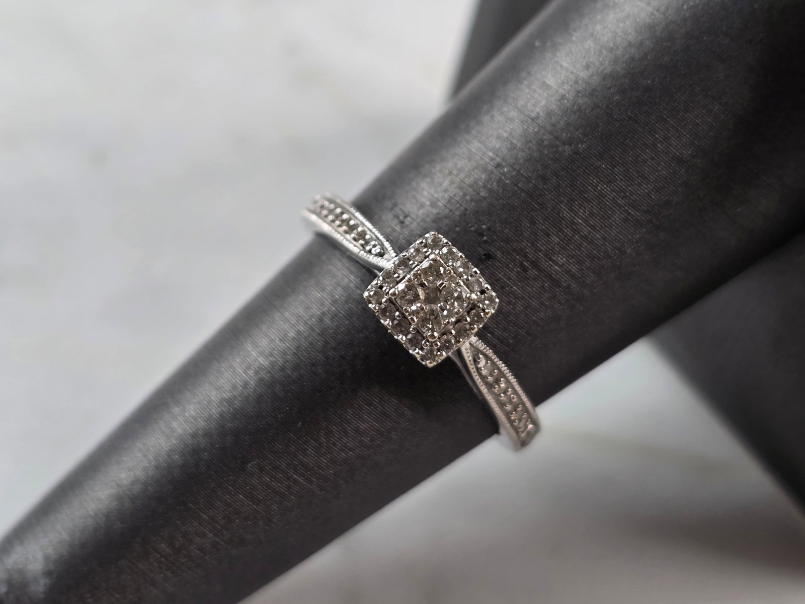 Womens Vintage Estate 10K White Gold Diamond Ring: A WOMENS VINTAGE ESTATE 10K WHITE GOLD DIAMOND RING. THE RING IS A SIZE 7.5 AND WEIGHS 2.2g. THERE ARE 5 SMALL DIAMONDS IN THE CENTER, SURROUNDED BY 16 TINY DIAMONDS, WITH 14 ACCENT DIAMONDS ALONG THE
