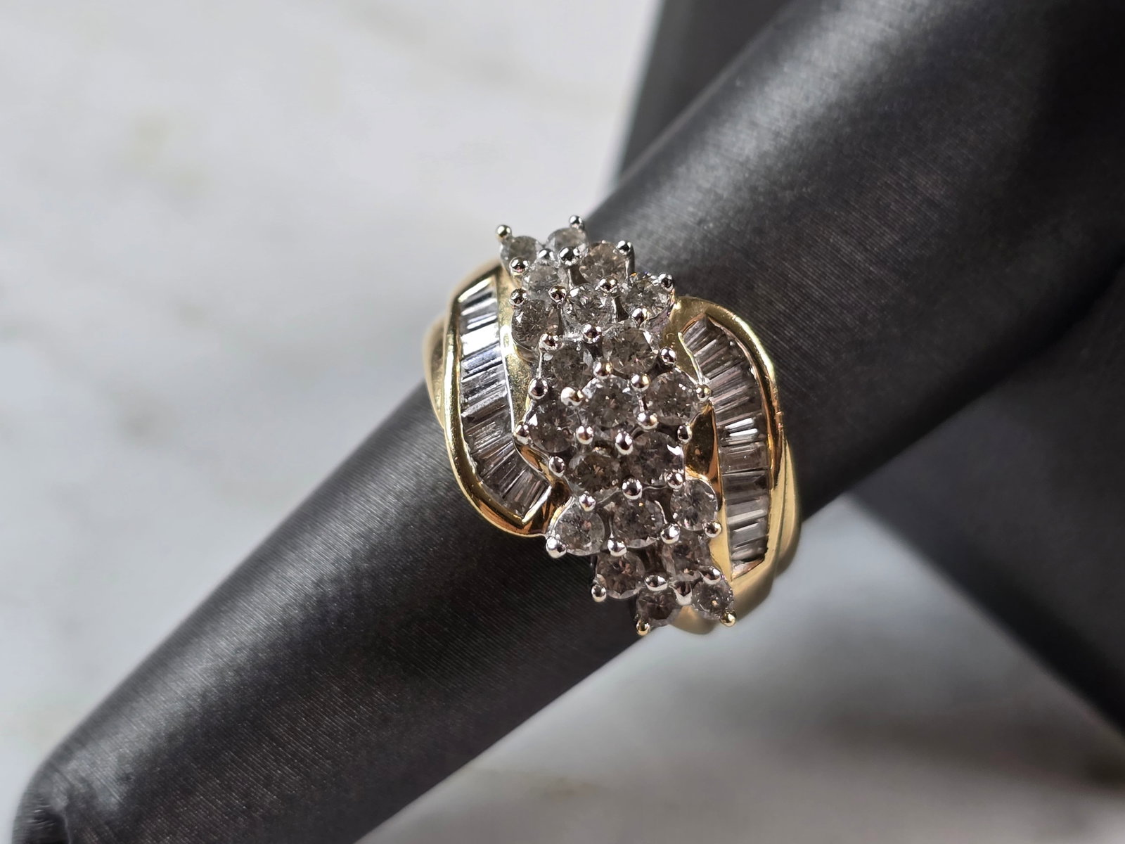 Womens Vintage Estate 14K Yellow Gold Modernist Diamond Ring: A WOMENS VINTAGE ESTATE 14K YELLOW GOLD MODERNIST DIAMOND RING. THE TOTAL WEIGHT IS 7.2g, AND IS A SIZE 7.5. THERE ARE ABOUT 0.63 cts OF SMALL ROUND DIAMONDS IN THE CENTER, WITH 20 BAGUETTES ACCENTING