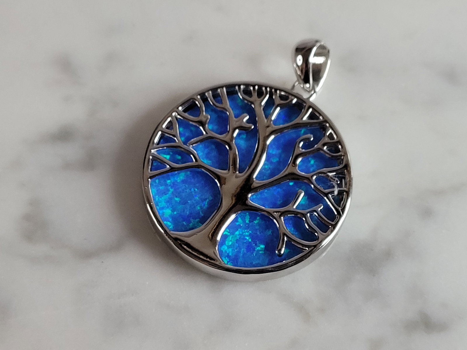 Womens Sterling Silver Blue Opal Tree of Life Pendant: A WOMENS ESTATE STERLING SILVER BLUE OPAL TREE OF LIFE PENDANT. NOT SURE IF STONES ARE REAL OR MAN MADE. THE PENDANT WEIGHS 6.2g AND MEASURES 1 1/8" LONG BY 1" WIDE. MAKES A GREAT GIFT FOR THAT SOMEON