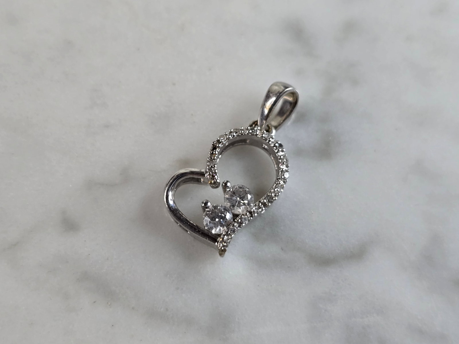 Womens Vintage Estate 10K White Gold Heart Diamond Pendant: A LOVELY VINTAGE ESTATE 10K WHITE GOLD DIAMOND HEART PENDANT. THE PENDANT WEIGHS 0.9g, AND MEASURES 5/8" LONG BY 3/8" WIDE. THERE ARE ABOUT .33cts OF DIAMONDS. THE TWO LARGER DIAMONDS ARE ABOUT 0.07ct