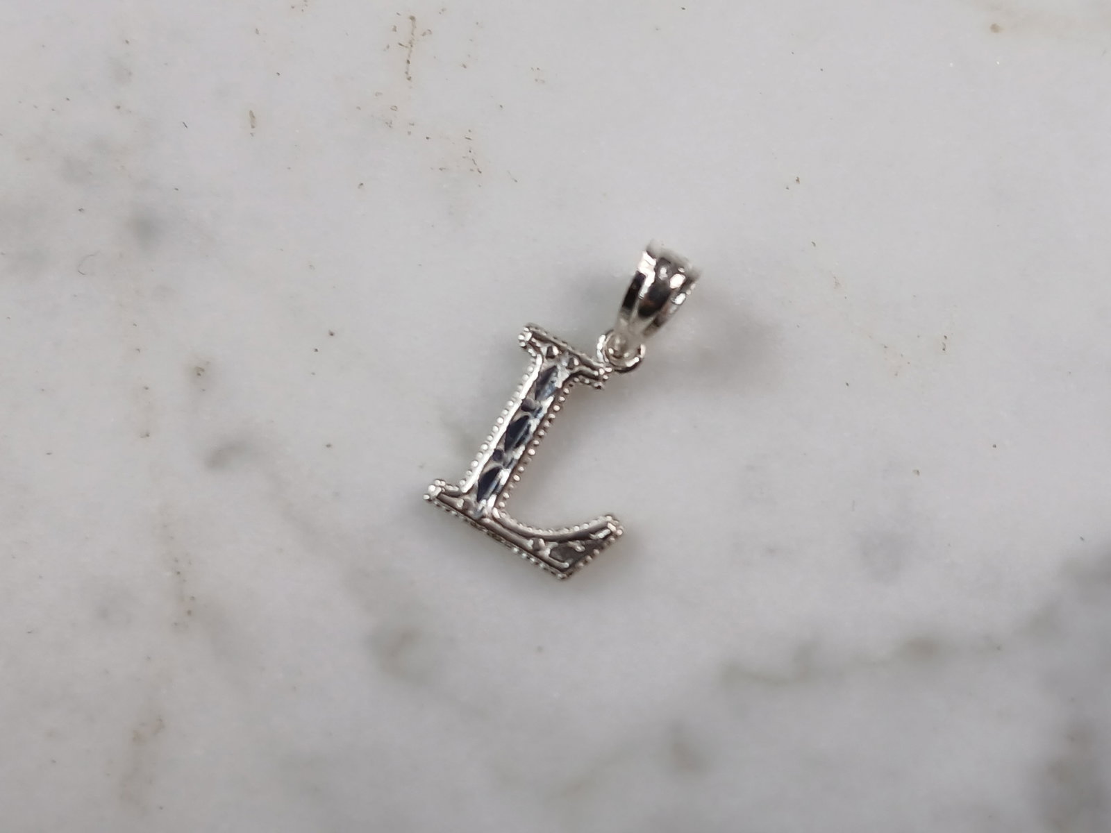 Womens Sterling Silver Initial Letter " L " Pendant: A WOMENS STERLING SILVER INITIAL LETTER "L" PENDANT. PENDANT WEIGHS 0.3g AND MEASURES 5/8" LONG BY 3/8" WIDE. MAKES A GREAT GIFT FOR THAT SOMEONE SPECIAL. ANY QUESTIONS, PLEASE ASK. BE SURE TO CHECK O