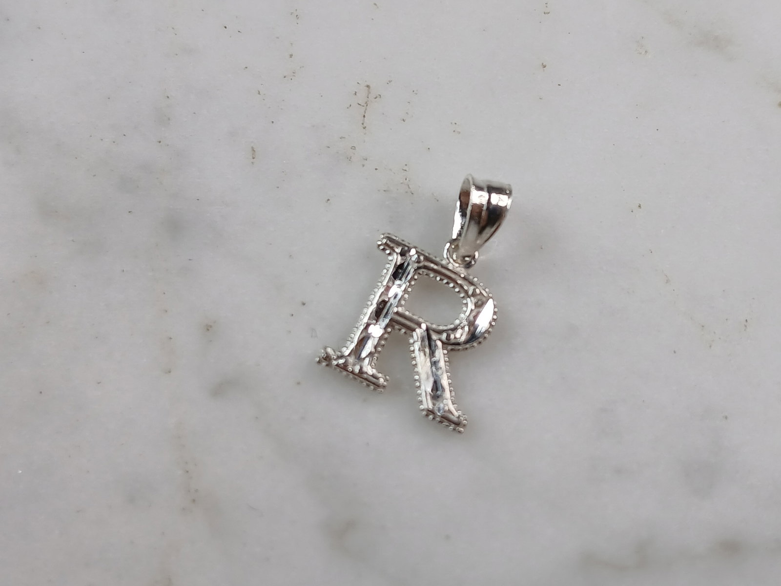 Womens Sterling Silver Initial Letter " R " Pendant: A WOMENS STERLING SILVER INITIAL LETTER "R" PENDANT. PENDANT WEIGHS 0.3g AND MEASURES 5/8" LONG BY 3/8" WIDE. MAKES A GREAT GIFT FOR THAT SOMEONE SPECIAL. ANY QUESTIONS, PLEASE ASK. BE SURE TO CHECK O