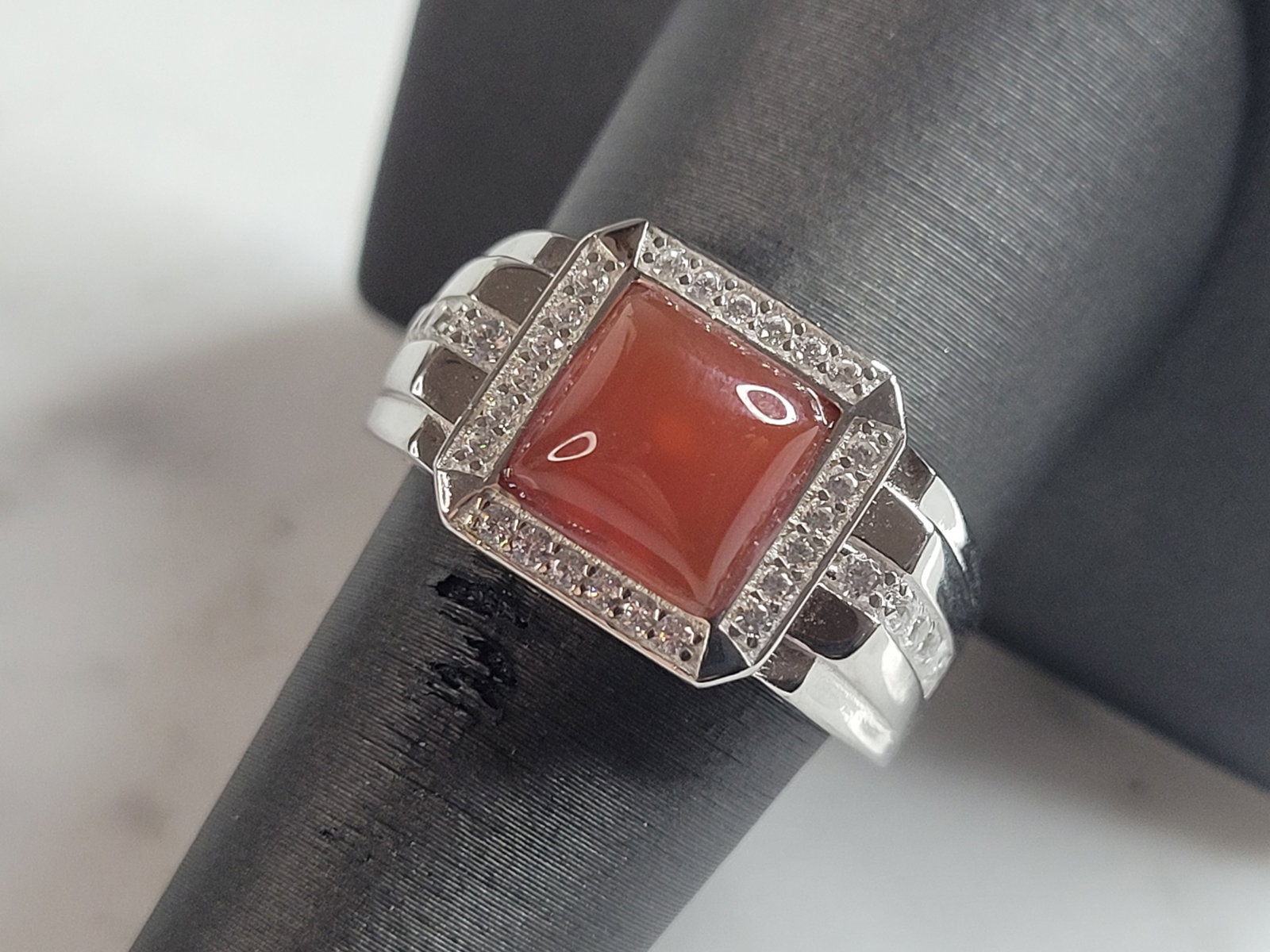 Mens Estate Sterling Silver Carnelian Ring: A MENS ESTATE STERLING SILVER CARNELIAN RING. THE RING IS A SIZE 9.25 AND WEIGHS 9.7g. NOT SURE IF THE STONE IS REAL OR MAN MADE. WIDTH OF THE RING IS ABOUT 1/2". THE RING MAKES A BEAUTIFUL, IMPRESSIV