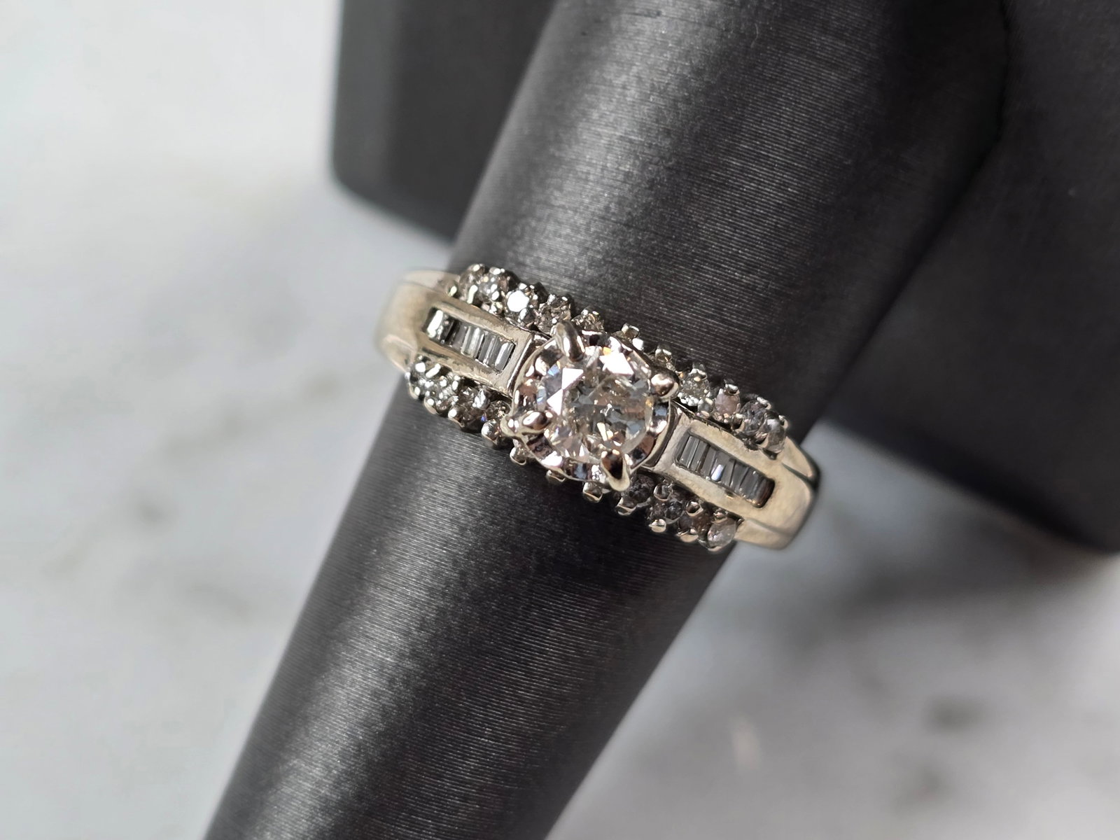 Womens Vintage Estate 14K White Gold Diamond Ring: A WOMENS VINTAGE ESTATE 14K WHITE GOLD DIAMOND RING. THE RING IS A SIZE 8.75 AND WEIGHS 5.7g. THE CENTER DIAMOND IS ABOUT .20cts , AND THERE ARE 22 SMALLER DIAMONDS WITH 16 BAGUETTE DIAMONDS. THE WIDT