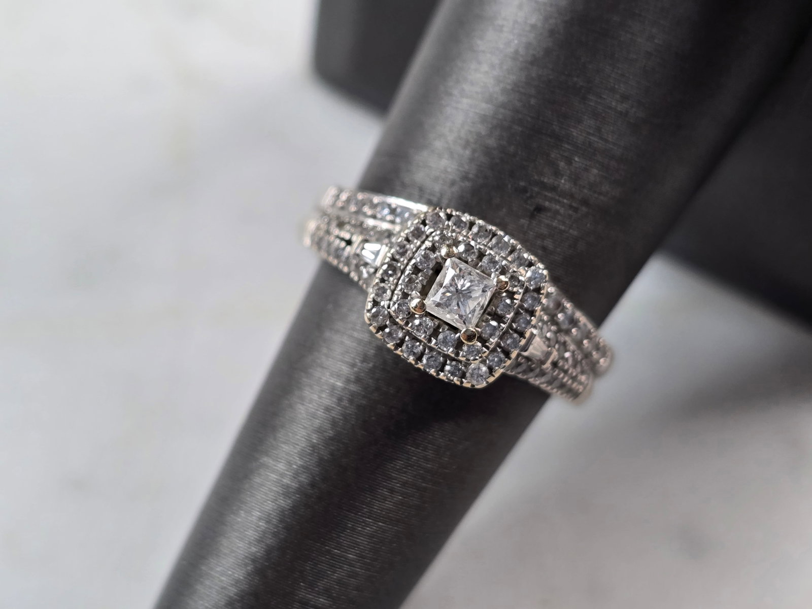 Womens Vintage Estate 10K White Gold Diamond Ring: A WOMENS VINTAGE ESTATE 10K WHITE GOLD DIAMOND RING. THE CENTER DIAMOND IS ABOUT .10cts, WITH ABOUT 76 ACCENT DIAMONDS AND 2 BAGUETTES. THE TOTAL WEIGHT IS 5.1g, AND IS A SIZE 7.25. THE WIDTH OF THE R