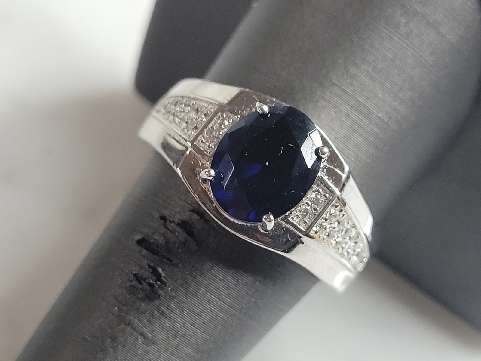 Mens Estate Sterling Silver Modernist Sapphire Ring: A MENS ESTATE STERLING SILVER MODERNIST RING. THE RING IS A SIZE 9.75 AND WEIGHS 9.7g. STONE IS A SAPPHIRE COLORED GLASS. WIDTH OF THE RING IS ABOUT 7/16". THE RING MAKES A BEAUTIFUL, IMPRESSIVE GIFT 