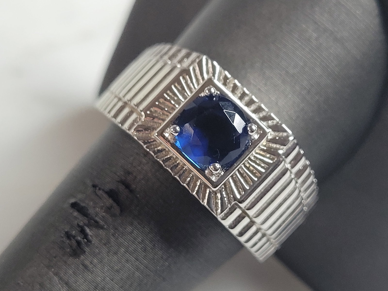 Mens Estate Sterling Silver Modernist Sapphire Ring: A MENS ESTATE STERLING SILVER MODERNIST RING. THE RING IS A SIZE 10.0 AND WEIGHS 10.1g. STONE IS A SAPPHIRE COLORED GLASS. WIDTH OF THE RING IS ABOUT 7/16". THE RING MAKES A BEAUTIFUL, IMPRESSIVE GIFT