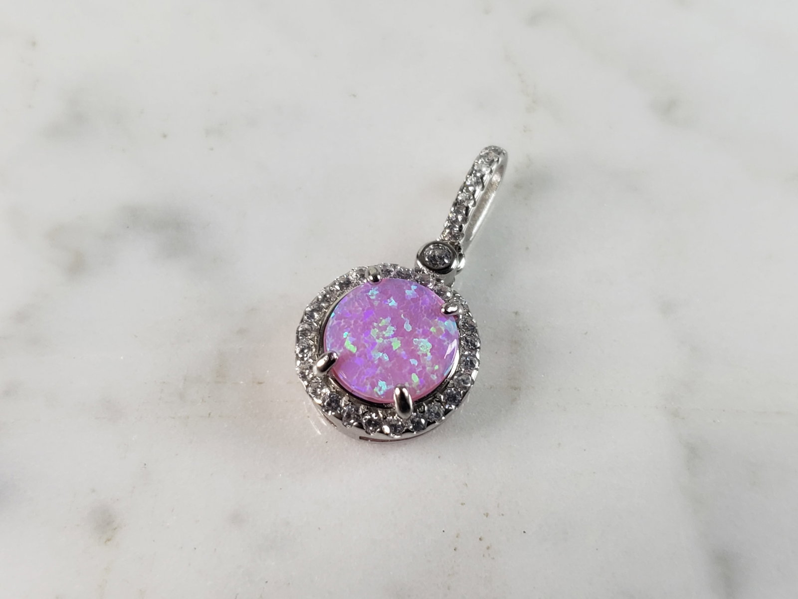 Womens Vintage Estate Sterling Silver Pink Opal Stone Pendant: A WOMENS ESTATE STERLING SILVER PINK OPAL STONE PENDANT. NOT SURE IF STONES ARE REAL OR MAN MADE. THE PENDANT WEIGHS 1.5g AND MEASURES 3/4" LONG BY 1/2" WIDE. MAKES A GREAT GIFT FOR THAT SOMEONE SPECI