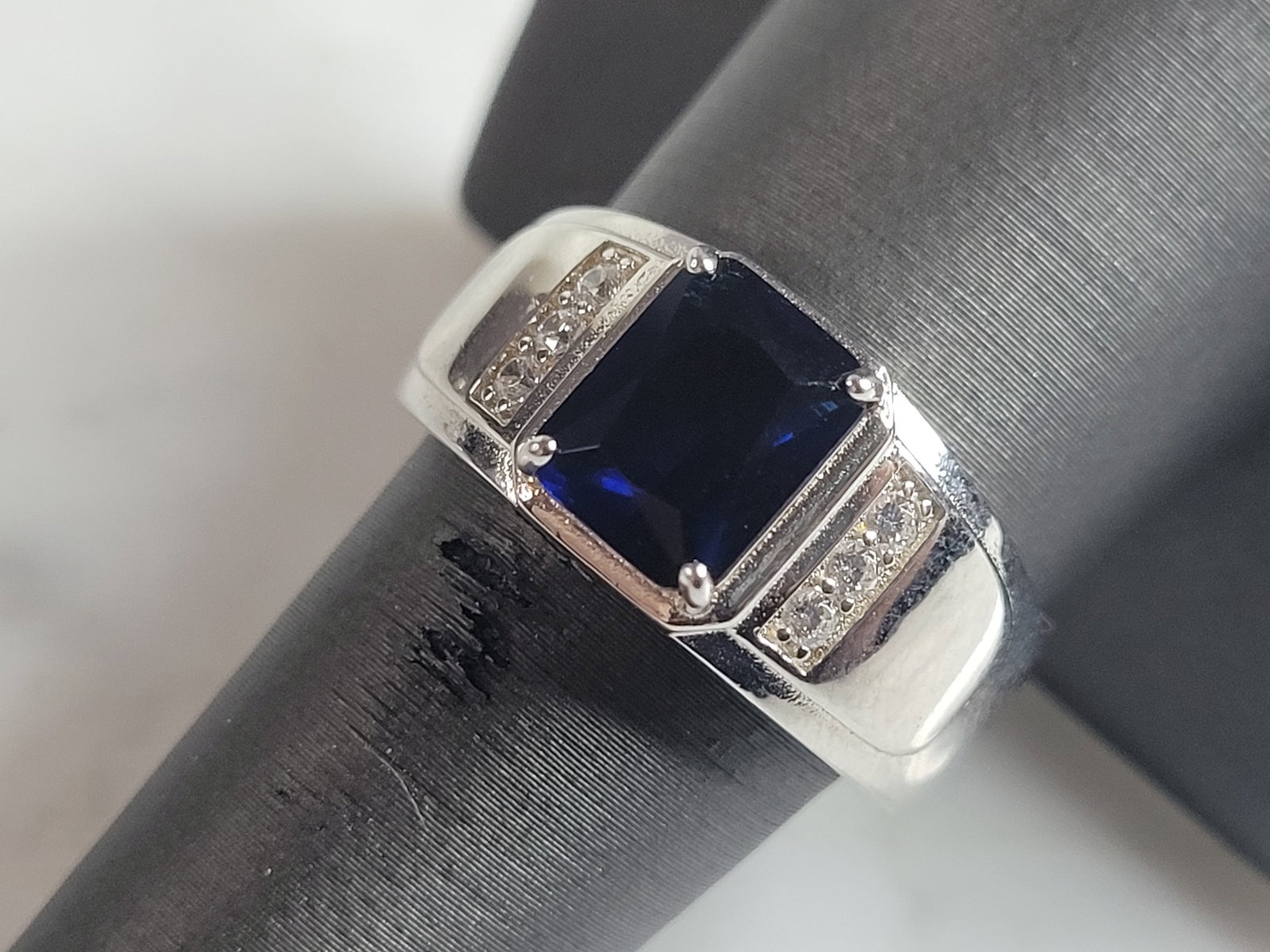 Mens Estate Sterling Silver Modernist Sapphire Ring: A MENS ESTATE STERLING SILVER MODERNIST RING. THE RING IS A SIZE 12.0 AND WEIGHS 10.2g. STONE IS A SAPPHIRE COLORED GLASS. WIDTH OF THE RING IS ABOUT 7/16". THE RING MAKES A BEAUTIFUL, IMPRESSIVE GIFT