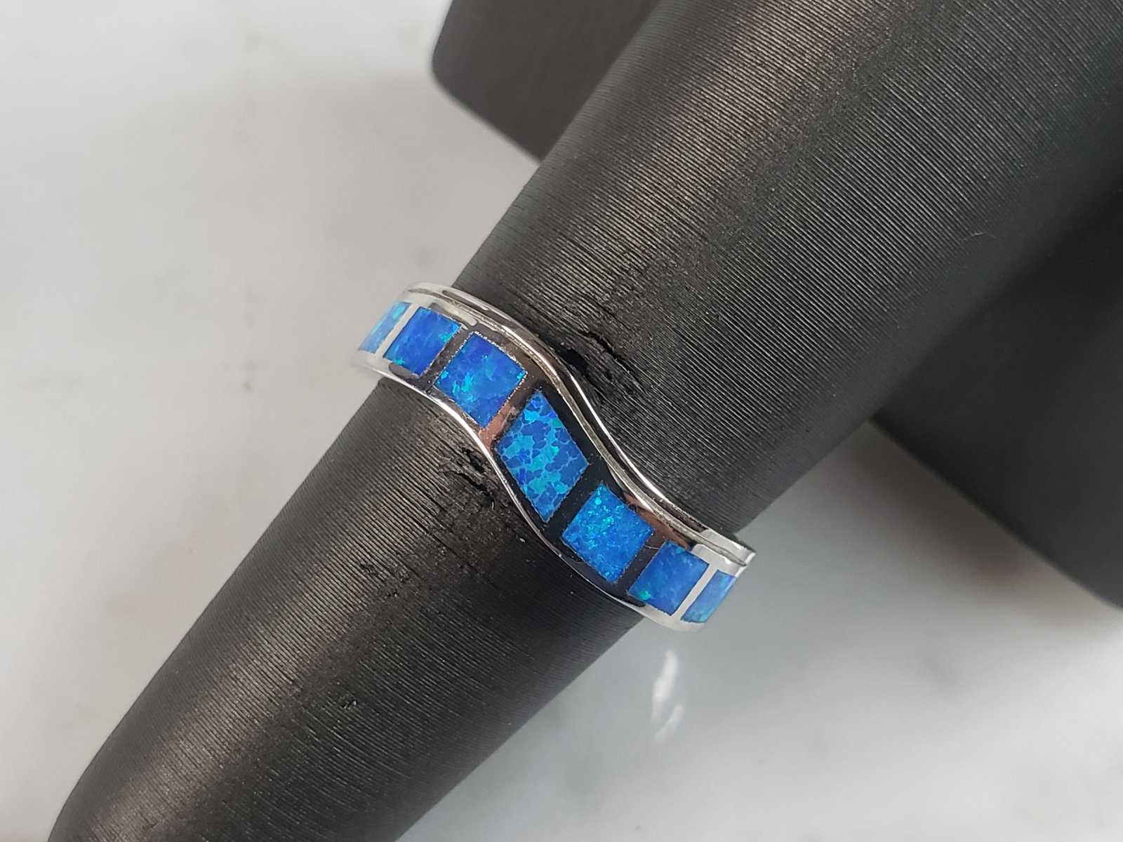 Womens Estate Sterling Silver Modernist Blue Opal Ring: A WOMENS ESTATE STERLING SILVER MODERNIST BLUE OPAL COLORED RING. THE RING IS A SIZE 6.75 AND WEIGHS 4.3g. WIDTH OF RING MEASURES 1/4". NOT SURE IF STONE IS NATURAL OR MAN MADE. THE RING MAKES A BEAUT