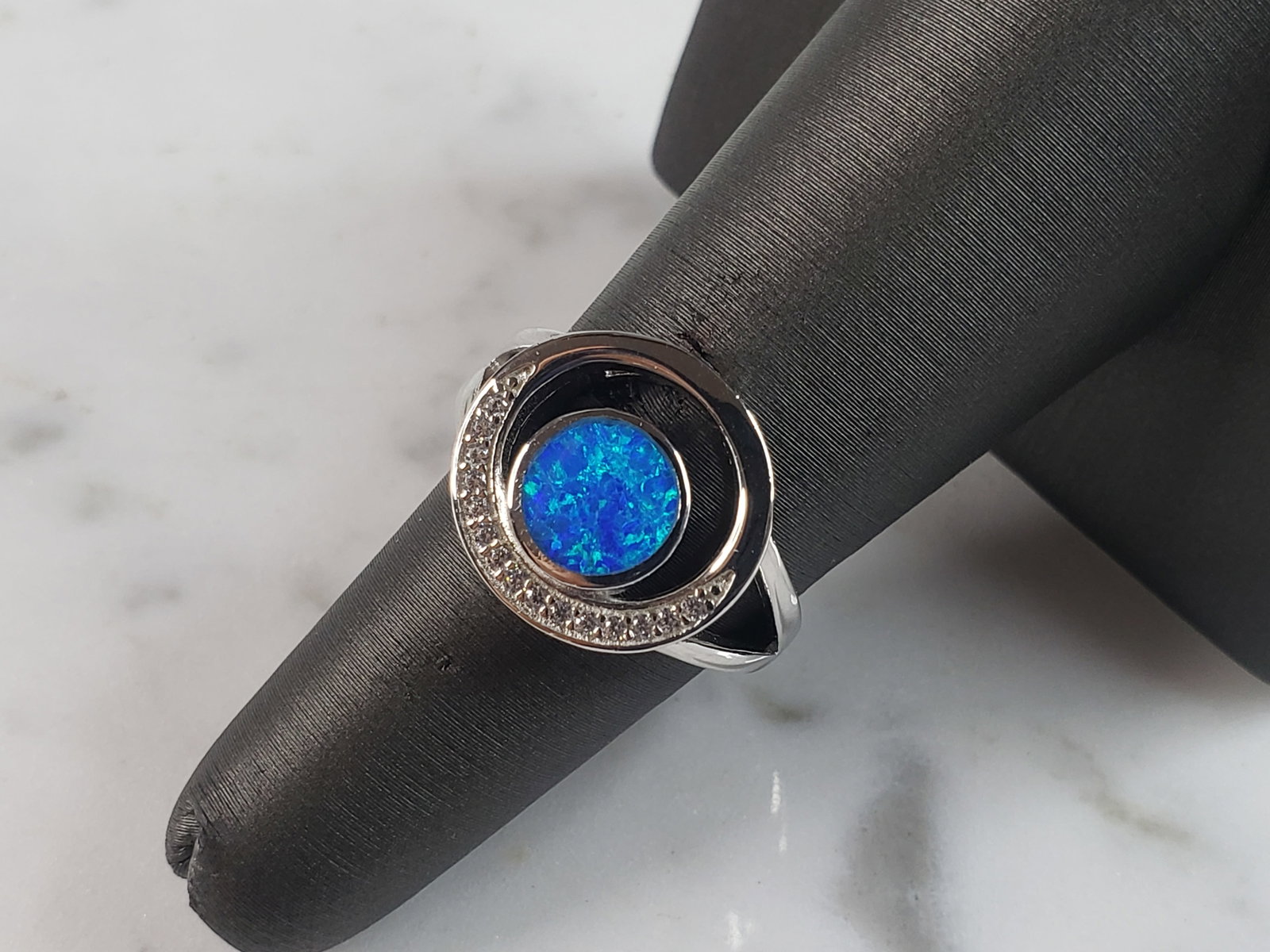 Womens Estate Sterling Silver Modernist Blue Opal & CZ Ring: A WOMENS ESTATE STERLING SILVER MODERNIST BLUE OPAL COLORED RING. THE RING IS A SIZE 6.0 AND WEIGHS 3.8g. WIDTH OF RING MEASURES 5/8". NOT SURE IF STONE IS NATURAL OR MAN MADE. THE RING MAKES A BEAUTI