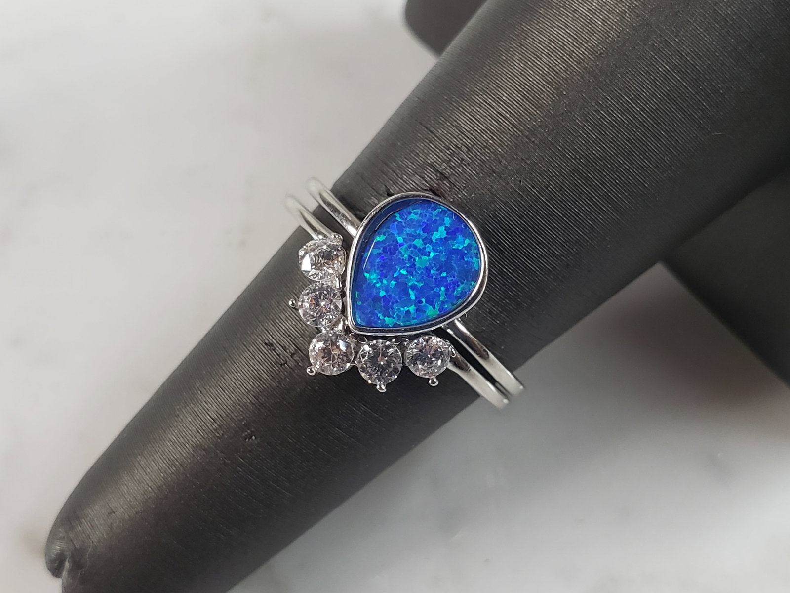 Womens Estate Sterling Silver Modernist Blue Opal & CZ Ring Set: A WOMENS ESTATE STERLING SILVER MODERNIST BLUE OPAL COLORED RING SET. THE RING IS A SIZE 6.25 AND WEIGHS 2.7g. WIDTH OF RING MEASURES 1/2". NOT SURE IF STONE IS NATURAL OR MAN MADE. THE RING MAKES A B