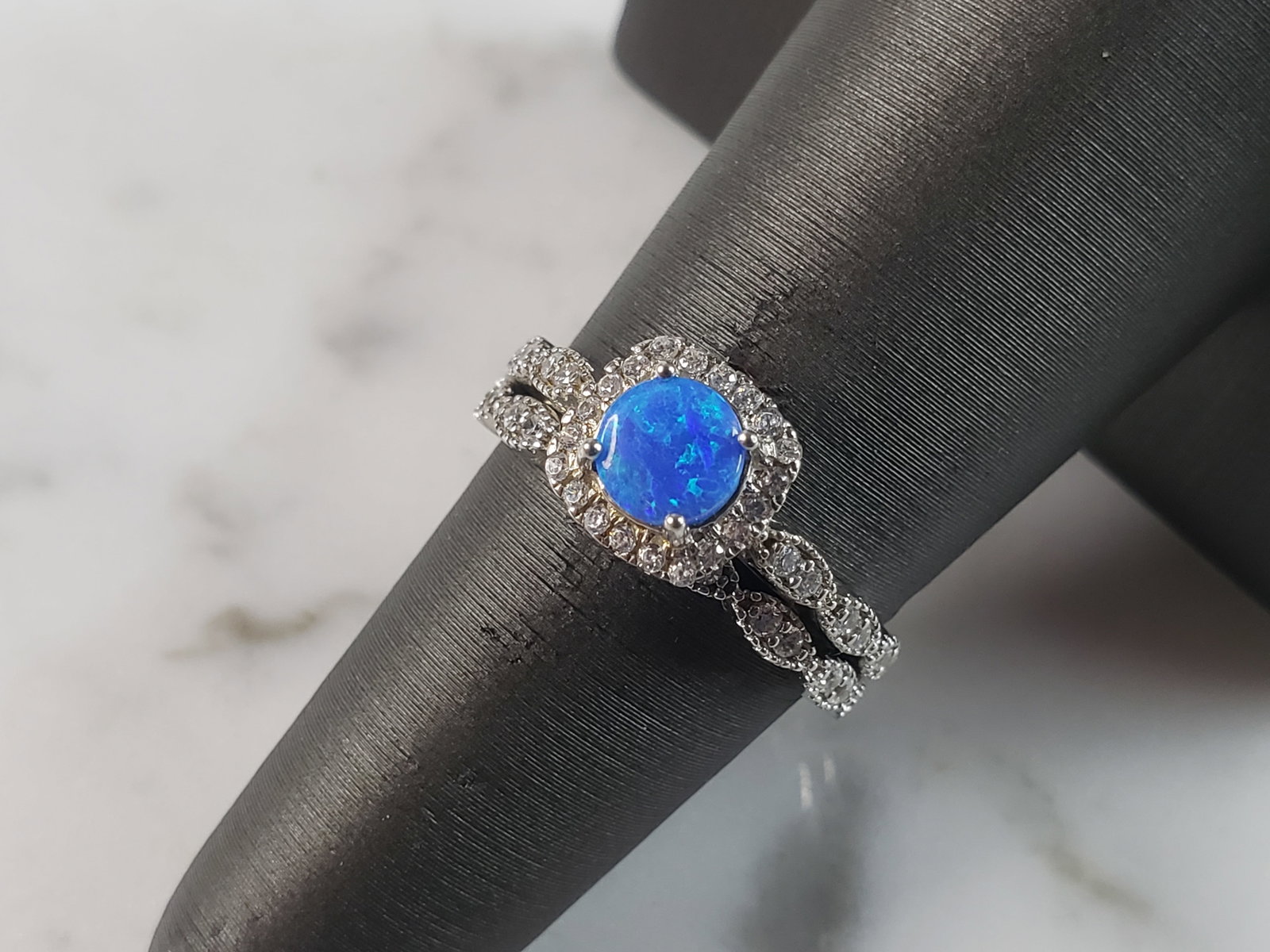 Womens Estate Sterling Silver Modernist Blue Opal & CZ Ring Set: A WOMENS ESTATE STERLING SILVER MODERNIST BLUE OPAL COLORED RING SET. THE RING IS A SIZE 6.0 AND WEIGHS 3.2g. WIDTH OF RING MEASURES 3/8". NOT SURE IF STONE IS NATURAL OR MAN MADE. THE RING MAKES A BE