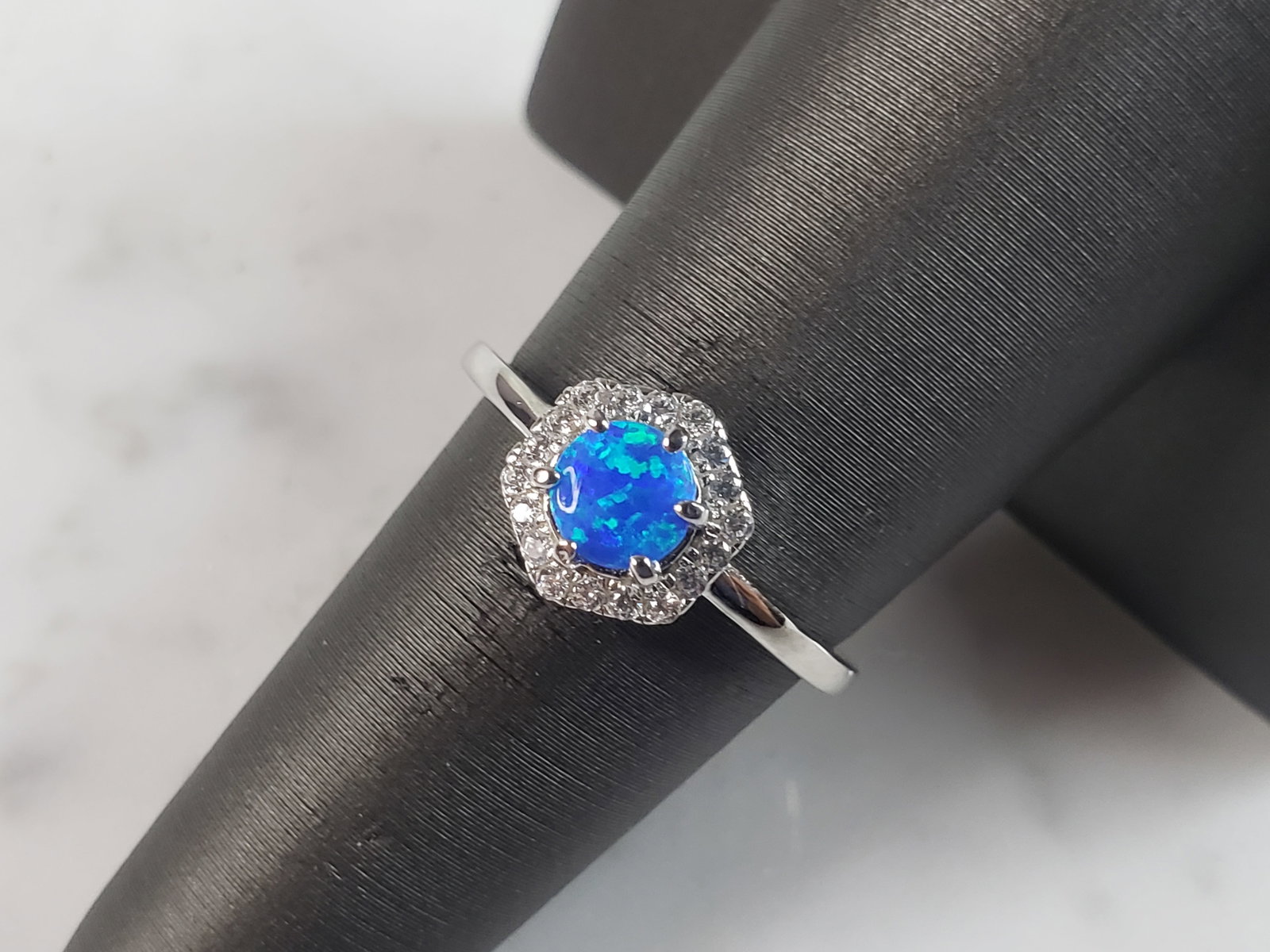 Womens Estate Sterling Silver Modernist Blue Opal & CZ Ring: A WOMENS ESTATE STERLING SILVER MODERNIST BLUE OPAL COLORED RING. THE RING IS A SIZE 7.0 AND WEIGHS 2.3g. WIDTH OF RING MEASURES 3/8". NOT SURE IF STONE IS NATURAL OR MAN MADE. THE RING MAKES A BEAUTI