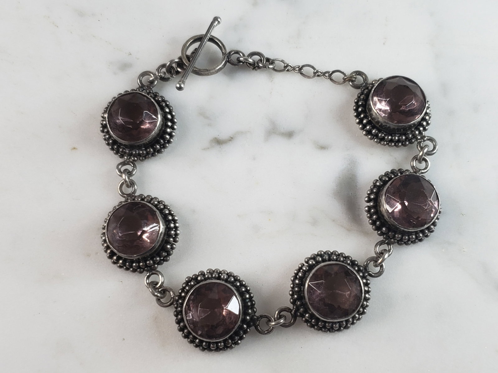 Womens Vintage Estate Sterling Silver Modernist Bracelet: A WOMENS VINTAGE ESTATE STERLING SILVER AMETHYST COLORED BRACELET. NOT SURE IF STONES ARE NATURAL OR MAN MADE. BRACELET MEASURES 7 3/4" LONG BY 3/4" WIDE AND WEIGHS 28.3g. THIS WOULD MAKE A LOVELY GIF