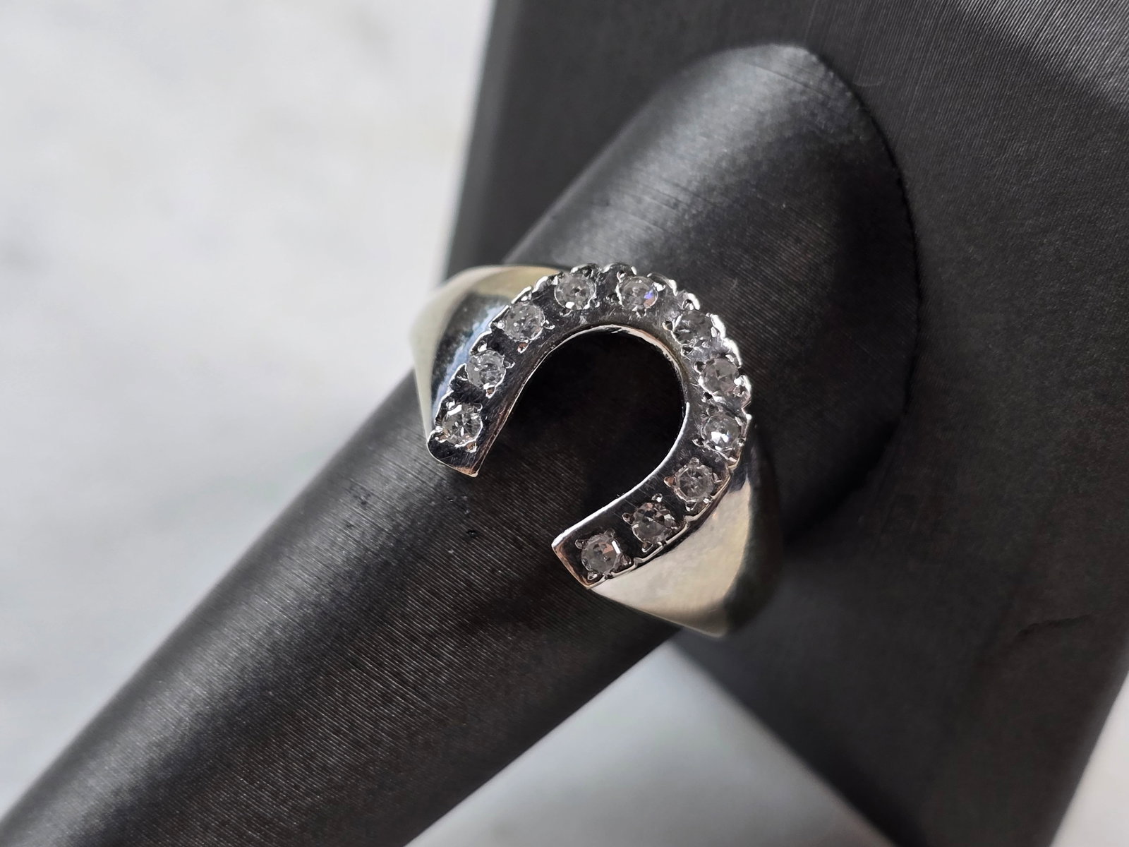 Mens Vintage Estate 10K White Gold Diamond Horseshoe Ring: A MENS VINTAGE ESTATE 10K WHITE GOLD DIAMOND HORSESHOE RING. RING WEIGHS 7.8g AND IS A SIZE 11.0. THERE ARE 11 SMALL DIAMONDS IN THIS RING. THE LENGTH OF THE RING IS 1/2". RING IS MARKED "10k". ANY QU