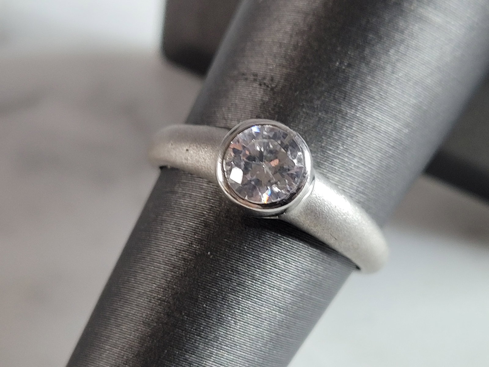 Womens Estate Sterling Silver Modernist CZ Ring: A WOMENS ESTATE STERLING SILVER MODERNIST CZ RING. THE RING WEIGHS 2.2g, AND IS A SIZE 7.0. THE WIDTH OF THE RING IS 1/4". AS YOU MAY BE ABLE TO SEE THE RING HAS A MATTE FINISH. THIS RING WOULD MAKE A