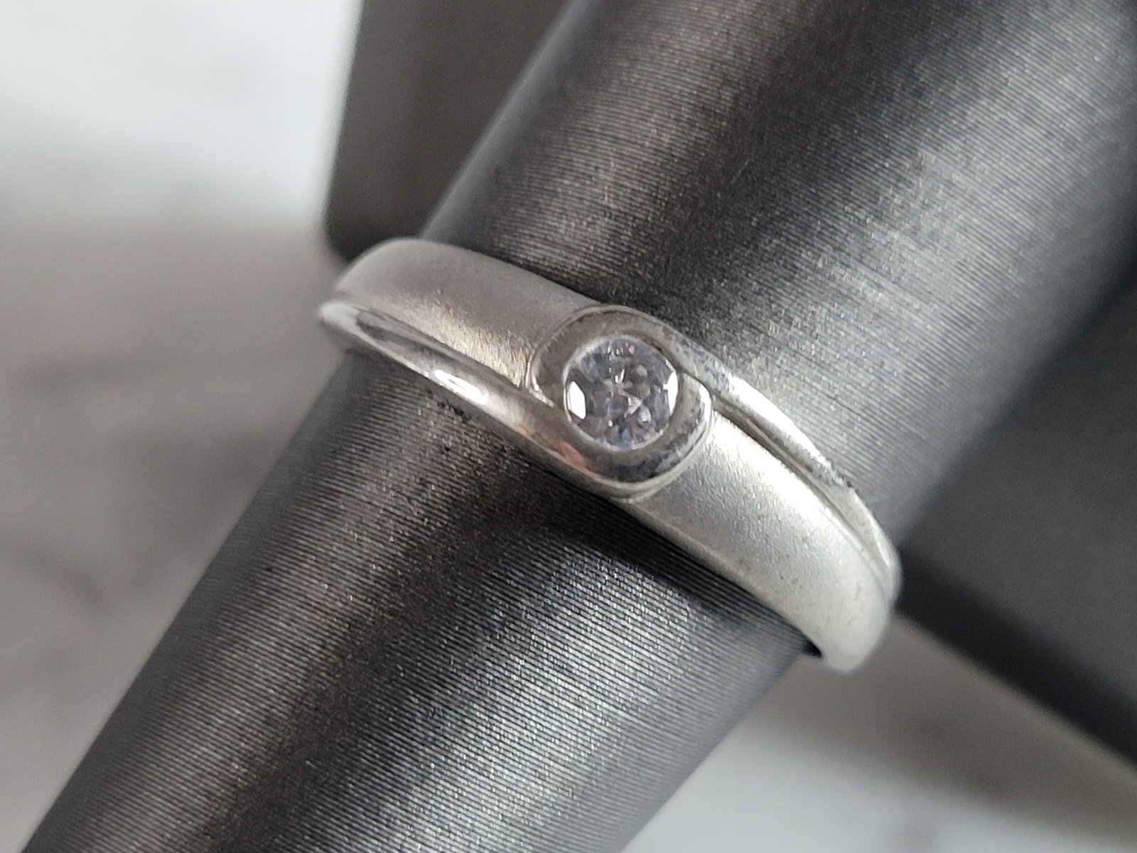 Womens Estate Sterling Silver Modernist CZ Ring: A WOMENS ESTATE STERLING SILVER MODERNIST CZ RING. THE RING WEIGHS 3.1g, AND IS A SIZE 5.75. THE WIDTH OF THE RING IS 3/16". AS YOU MAY BE ABLE TO SEE THE RING HAS A MATTE FINISH. THIS RING WOULD MAKE