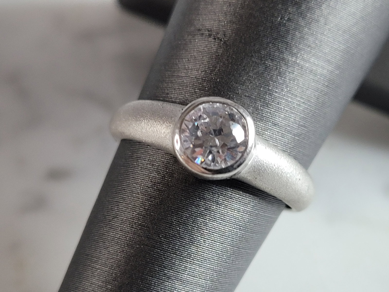 Womens Estate Sterling Silver Modernist CZ Ring: A WOMENS ESTATE STERLING SILVER MODERNIST CZ RING. THE RING WEIGHS 2.4g, AND IS A SIZE 6.5. THE WIDTH OF THE RING IS 1/4". AS YOU MAY BE ABLE TO SEE THE RING HAS A MATTE FINISH. THIS RING WOULD MAKE A