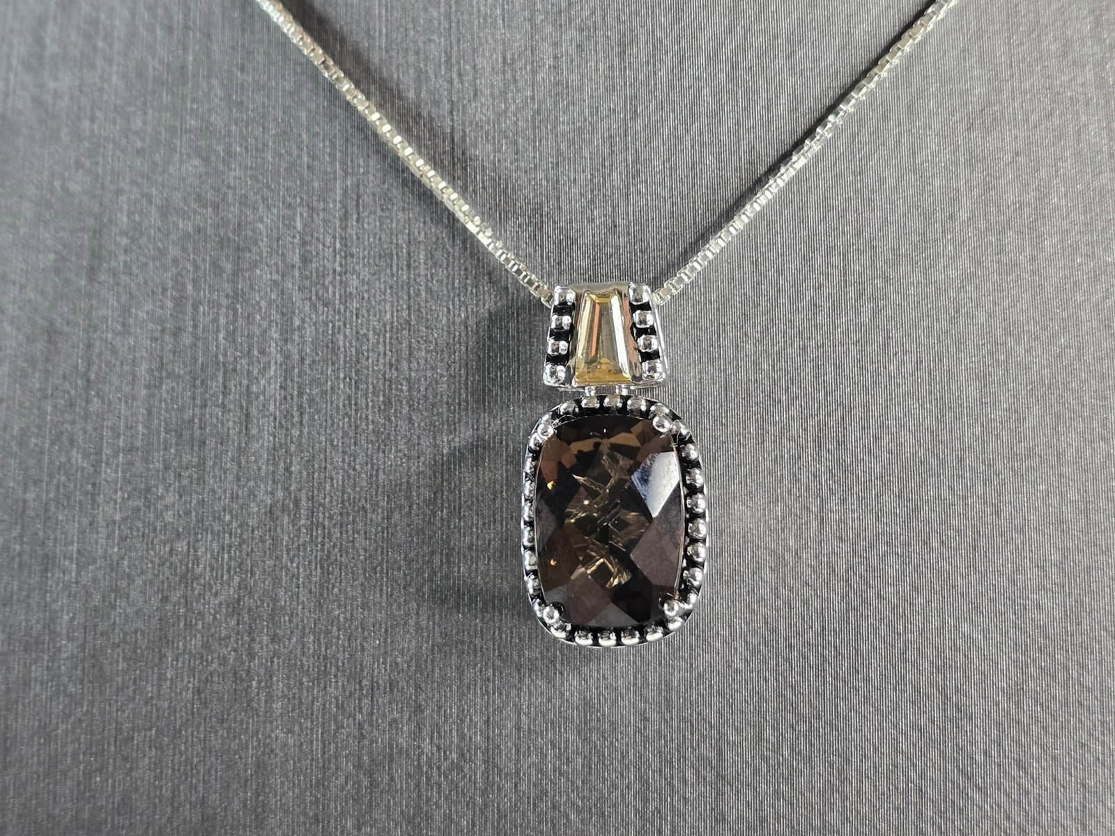 Womens Vintage Sterling Silver Smoky Quartz Pendant Necklace: A WOMENS VINTAGE ESTATE STERLING SILVER NECKLACE WITH A SMOKY QUARTZ PENDANT. TOGETHER THEY WEIGHS 7.2g. NOT SURE IF STONE IS NATURAL OR MAN MADE. THE NECKLACE MEASURES 18" LONG AND THE PENDANT MEASUR