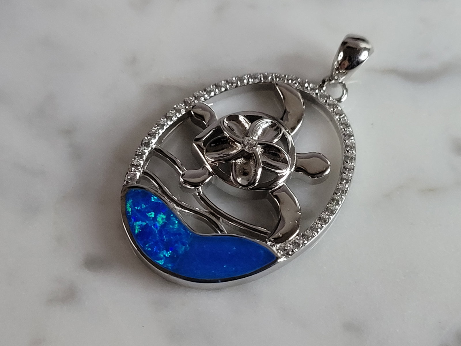 Womens Sterling Silver Blue Opal Sea Turtle Pendant: A WOMENS ESTATE STERLING SILVER BLUE OPAL SEA TURTLE PENDANT. NOT SURE IF STONES ARE REAL OR MAN MADE. THE PENDANT WEIGHS 5.3g AND MEASURES 1 3/8" LONG BY 3/4" WIDE. MAKES A GREAT GIFT FOR THAT SOMEON