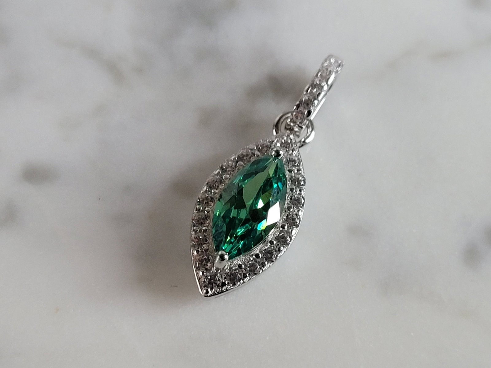 Womens Estate Sterling Silver Modernist CZ Pendant: A WOMENS ESTATE STERLING SILVER MODERNIST CZ PENDANT WITH AN EMERALD COLORED STONE. PENDANT WEIGHS 1.7g AND MEASURES 7/8" LONG BY 3/8" WIDE. MAKES A GREAT GIFT FOR THAT SOMEONE SPECIAL. ANY QUESTIONS,