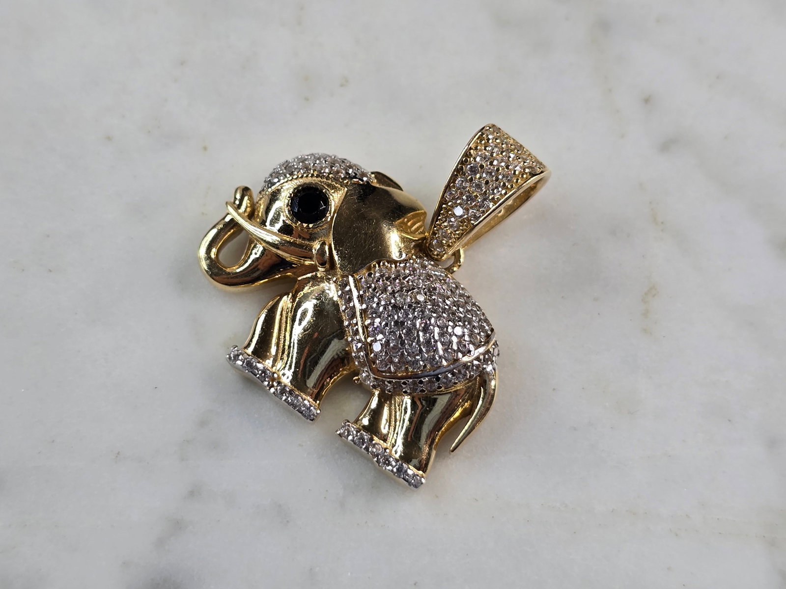 Womens Vintage Estate 14K Gold CZ Onyx Elephant Pendant: A WOMENS VINTAGE ESTATE 14K YELLOW GOLD ELEPHANT PENDANT WITH CZ ACCENTS AND AN ONYX EYE. PENDANT MEASURES 1" LONG BY 1" WIDE. TOTAL WEIGHT OF THE PENDANT IS 6.0g. PENDANT IS MARKED ON THE BALE. WOULD