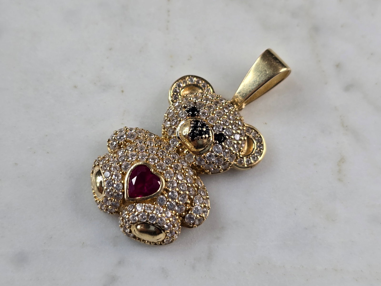 Womens Vintage Estate 14K Gold CZ Teddy Bear Heart Pendant: A WOMENS VINTAGE ESTATE 14K YELLOW GOLD TEDDY BEAR PENDANT WITH CZ ACCENTS AND A PINK SAPPHIRE HEART. PENDANT MEASURES 1 1/2" LONG BY 3/4" WIDE. TOTAL WEIGHT OF THE PENDANT IS 6.1g. PENDANT IS FAINTLY