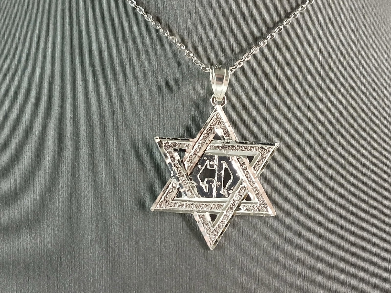Sterling Silver Jewish Judaica Star of David Pendant Necklace: A STERLING SILVER STAR OF DAVID PENDANT WITH NECKLACE. THE PENDANT WITH NECKLACE WEIGHS 3.1g. THE NECKLACE MEASURES 18" LONG, AND IS ADJUSTABLE TO 16" LONG. THE PENDANT MEASURES 1 1/4" LONG BY 7/8" WI