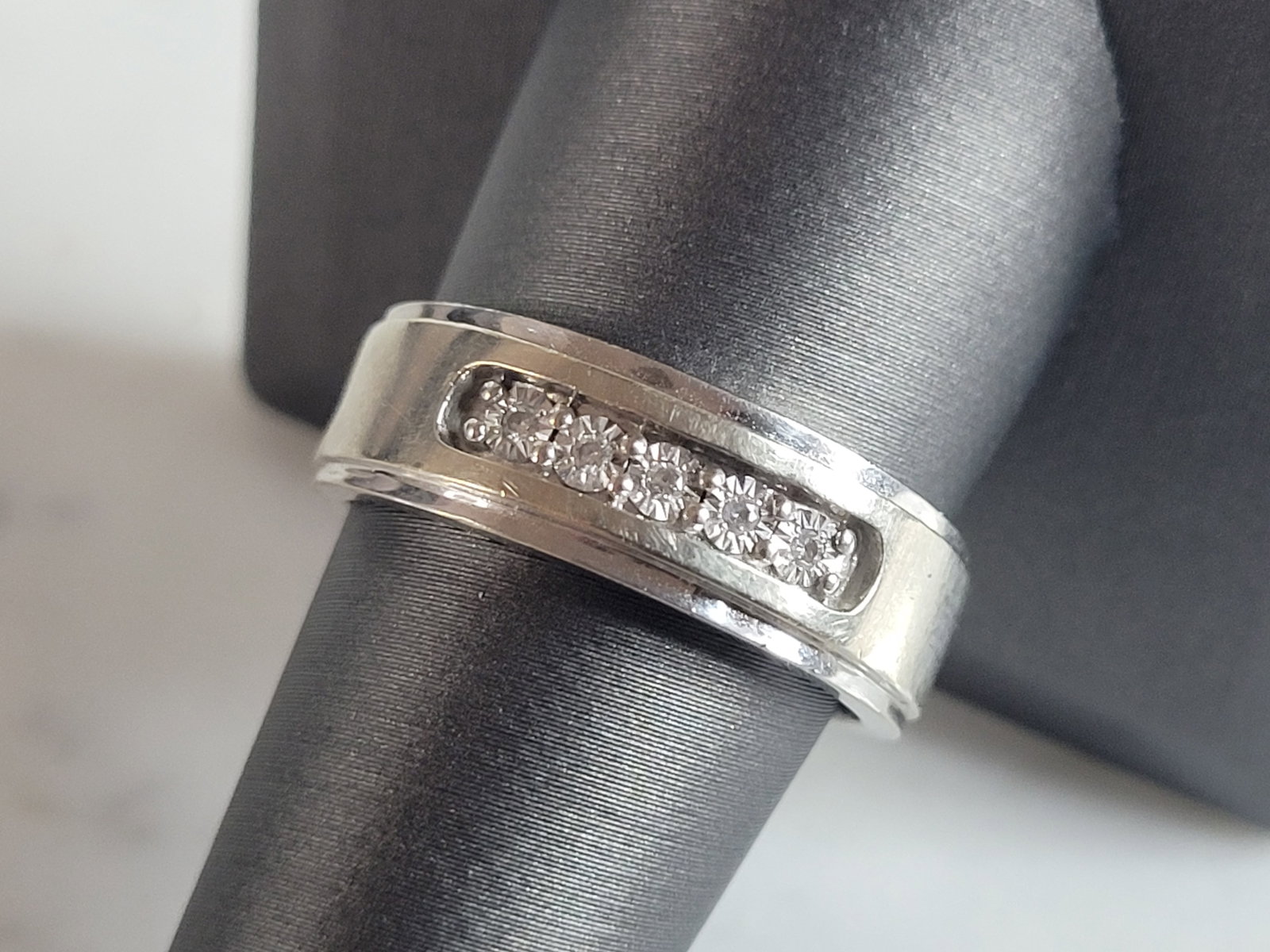 Mens Vintage Estate 10k White Gold Diamond Ring: A MENS VINTAGE ESTATE 10K WHITE GOLD DIAMOND RING. THE RING WEIGHS 4.9g AND IS A SIZE 9.75. THE CARAT WEIGHT OF THE DIAMONDS ARE ABOUT .25cts. RING IS MARKED ON THE INSIDE OF THE BAND. THE WIDTH OF TH